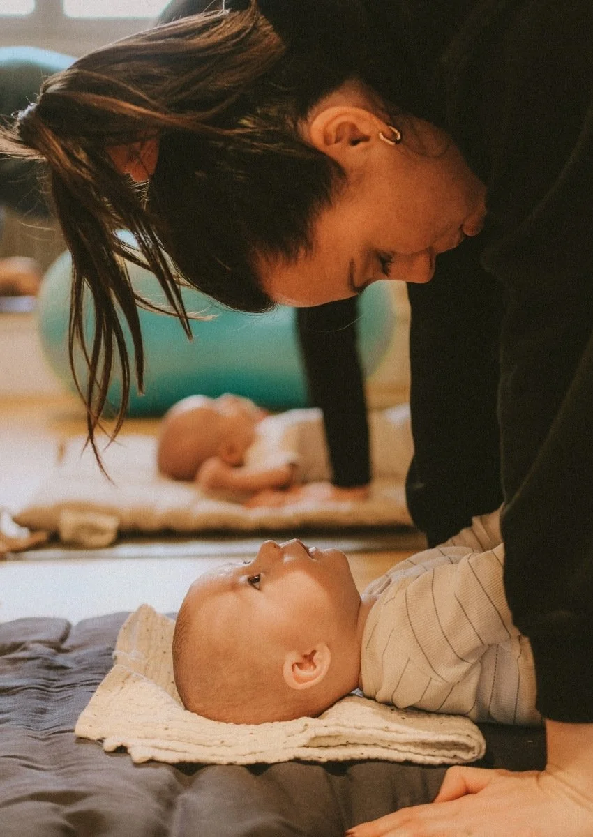 Maman réalisant des postures de yoga durant la séance baby yoga avec son enfant
