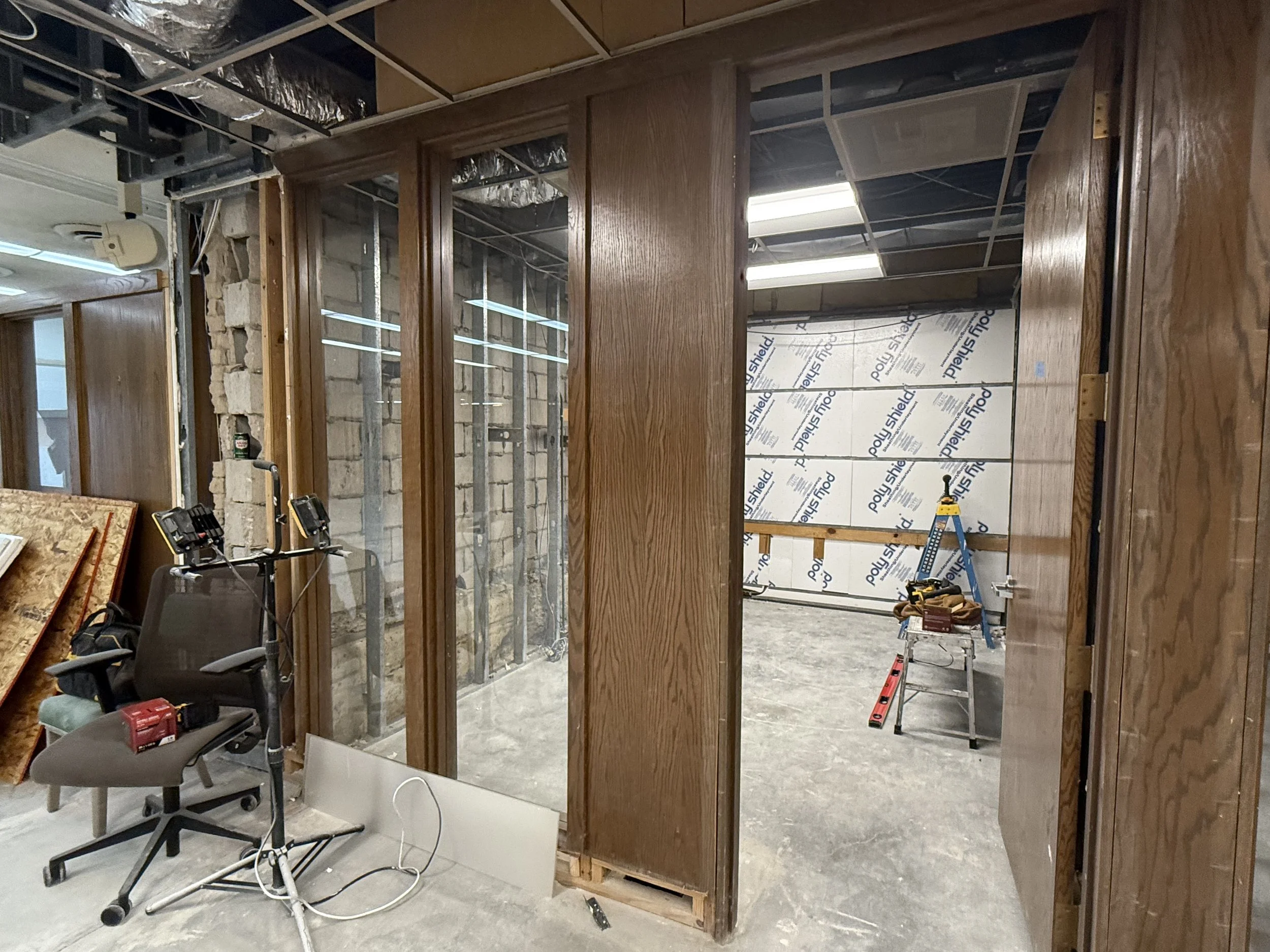 Interior under construction with wooden framing, tools, and unfinished walls.