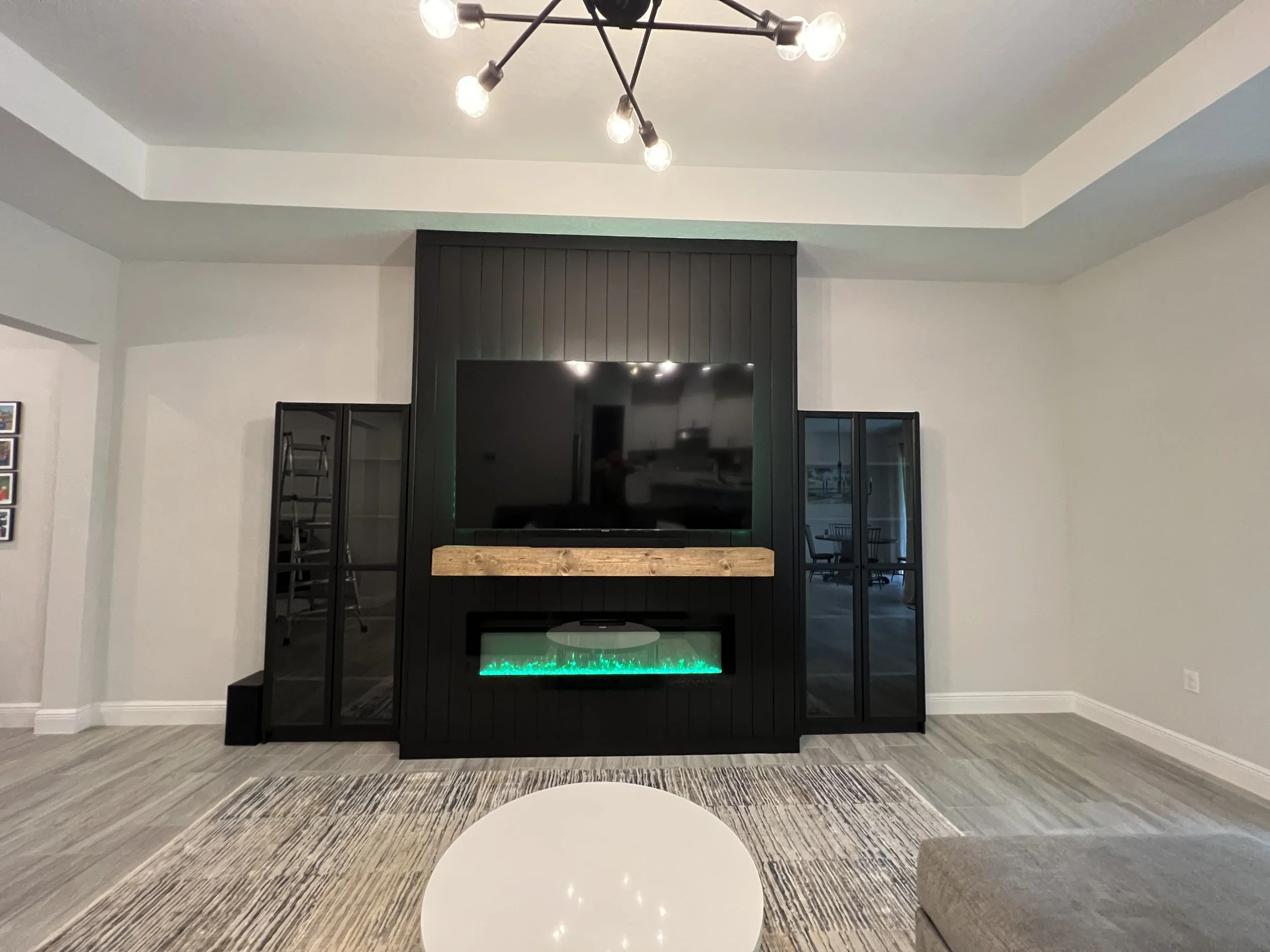 Custom built and designed by us in 2023 for a living room built in and custom paint job utilizing cabinet painting and tv mounted flush with unit. give a nice rich elegant feel for this Ormond Beach Home 