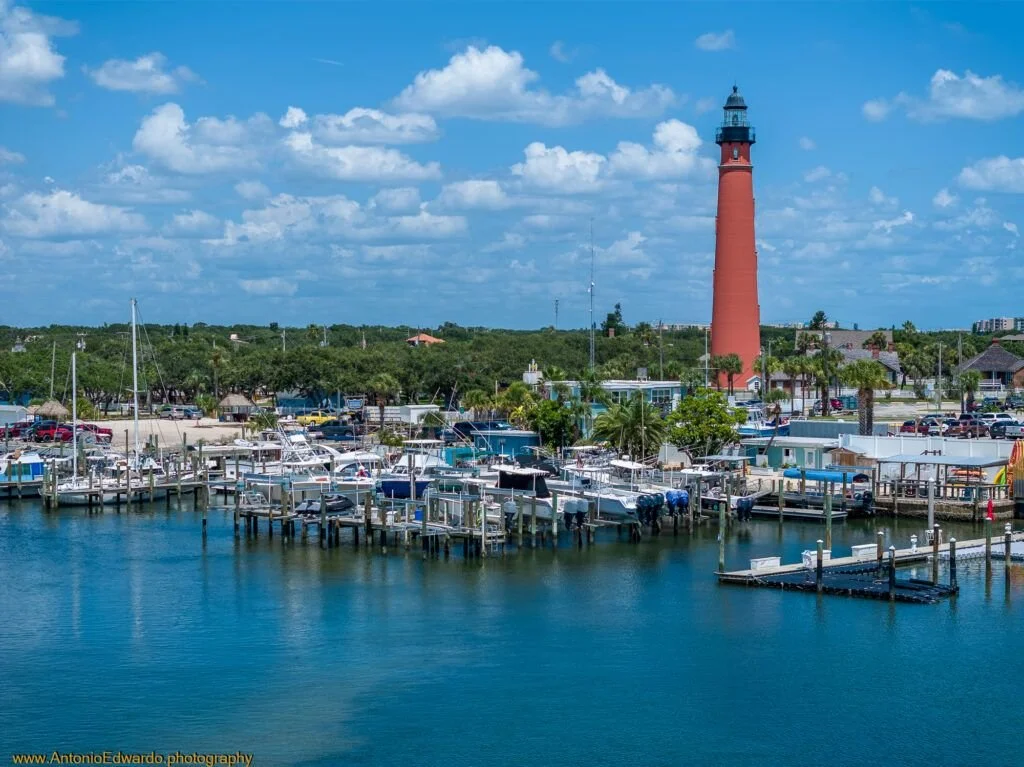 Ponce Inlet Florida marina with boats docked, a red lighthouse Ponce Inlet Florida, an area we work and service in.