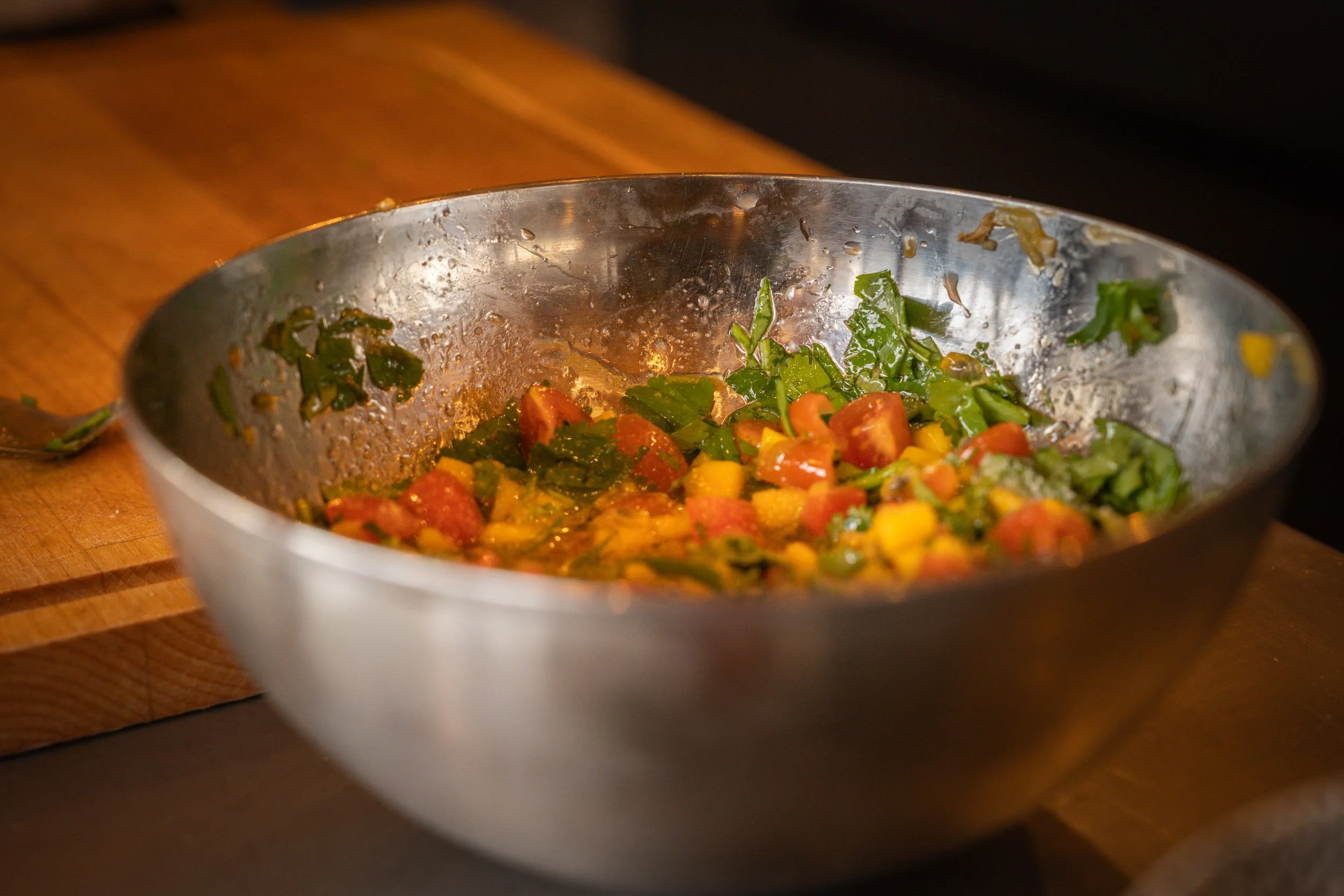 Salade de légumes coupés dans un bol en acier inoxydable sur une table en bois.