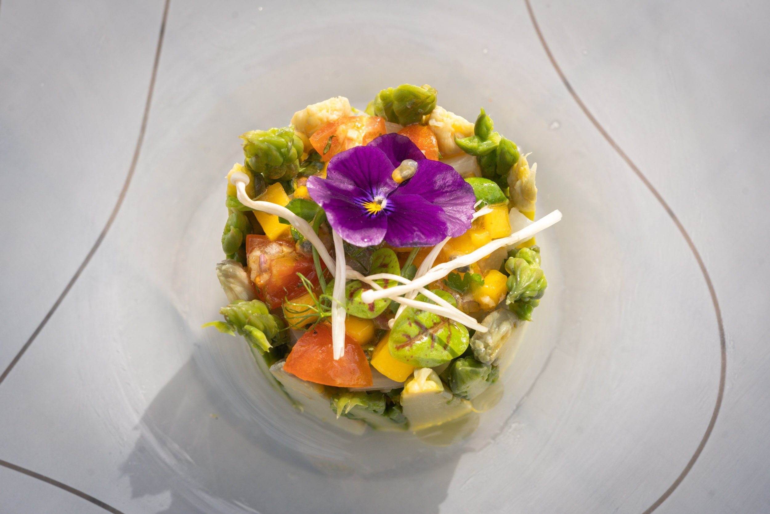 Salade de légumes frais avec une fleur violette comestible en garniture