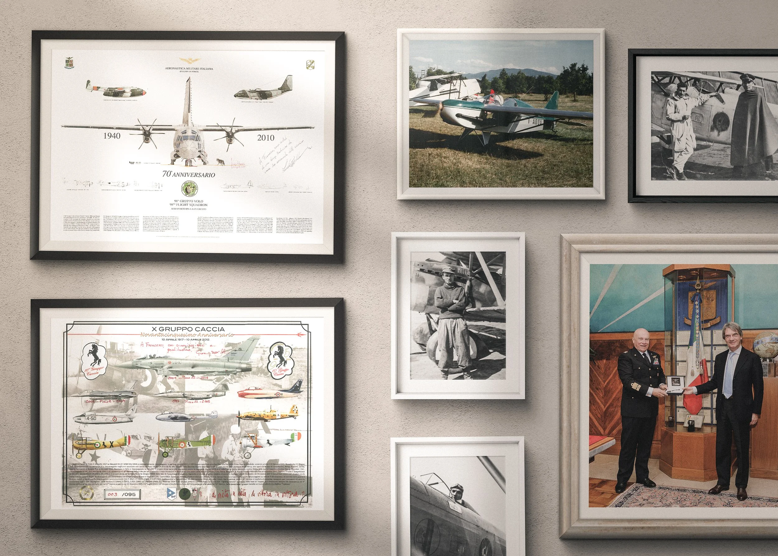 A wall decorated with framed aviation photographs and certificates, including airplane illustrations, historical black and white photos, modern photos of small planes, and a picture of two men in a formal setting shaking hands.