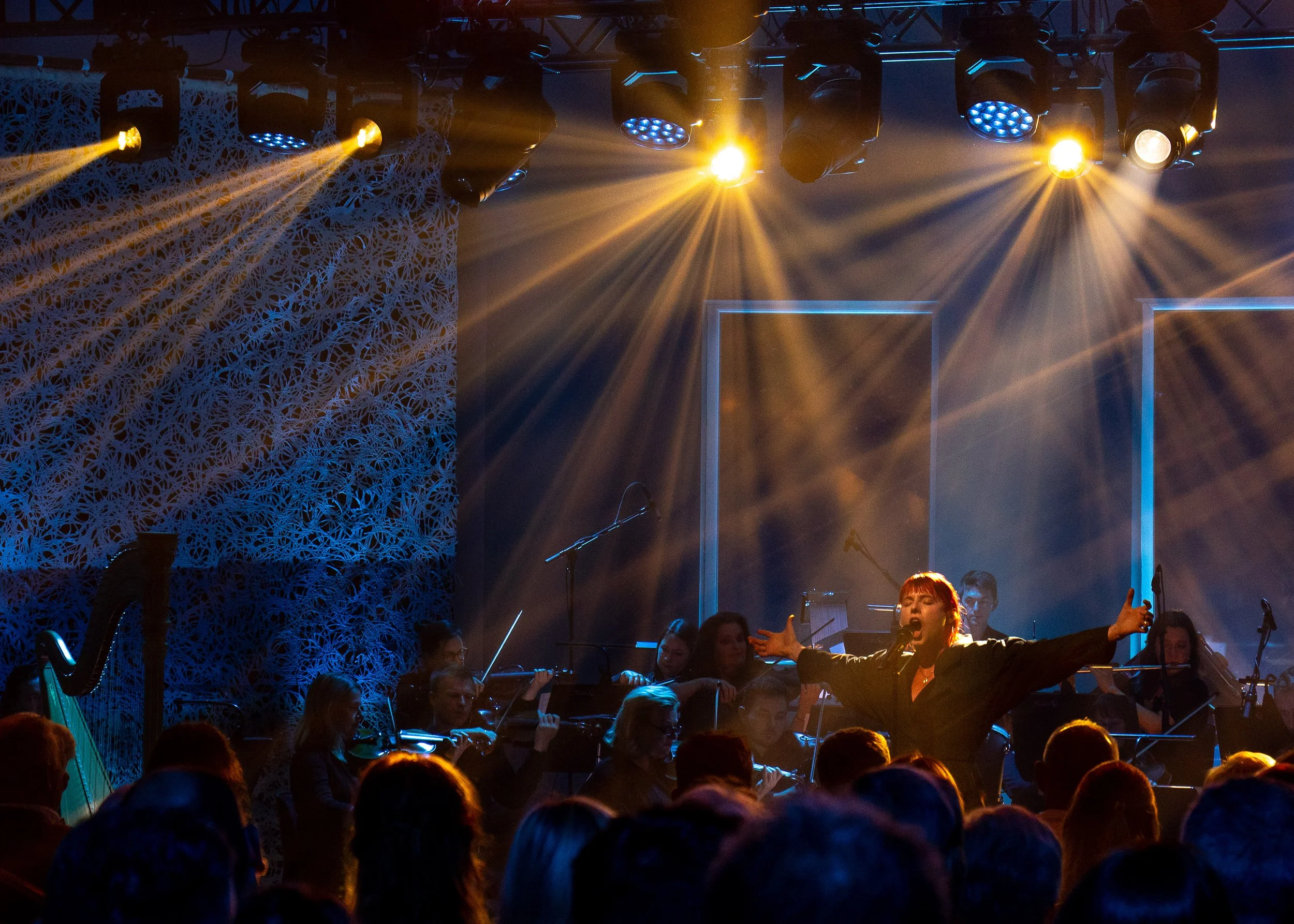 A group of musicians performing on stage with colorful stage lighting and decorative backdrop. Event Photography in Donegal. Event Videography. Event videographer. 