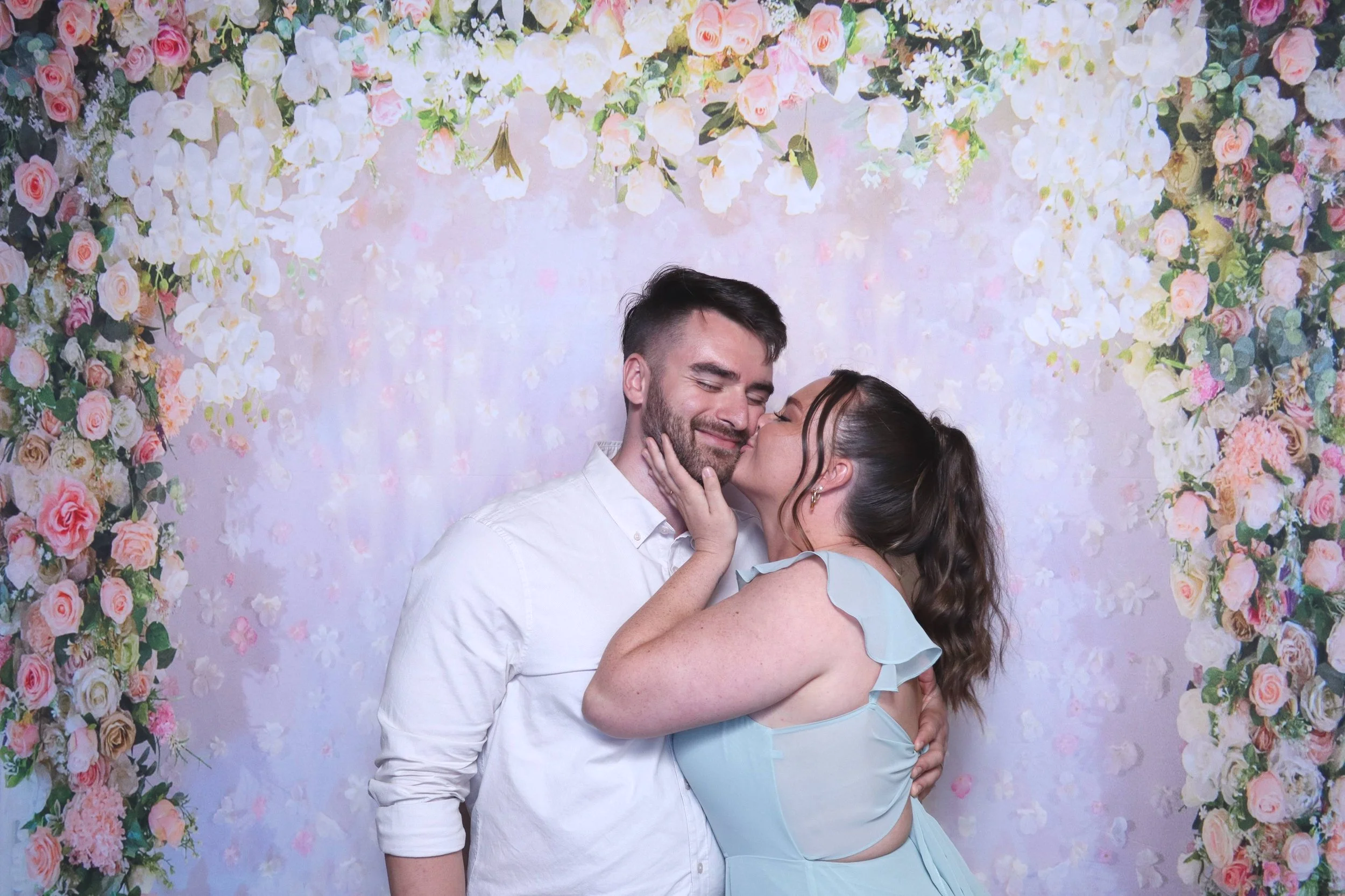 Guests kissing in front of studio photo booth in whidbey island, WA