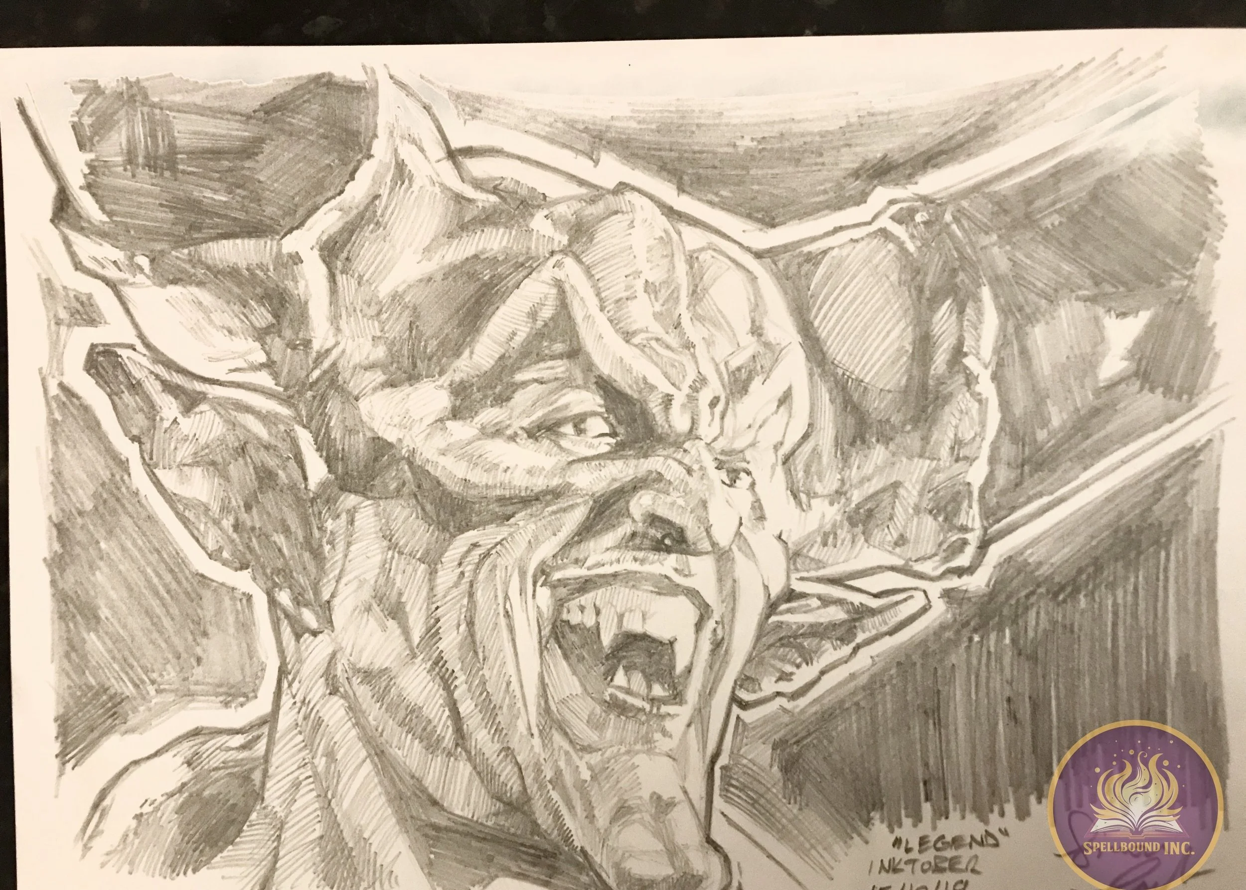 Black and white pencil sketch of a monstrous creature with pointed ears, sharp teeth, and an angry expression.