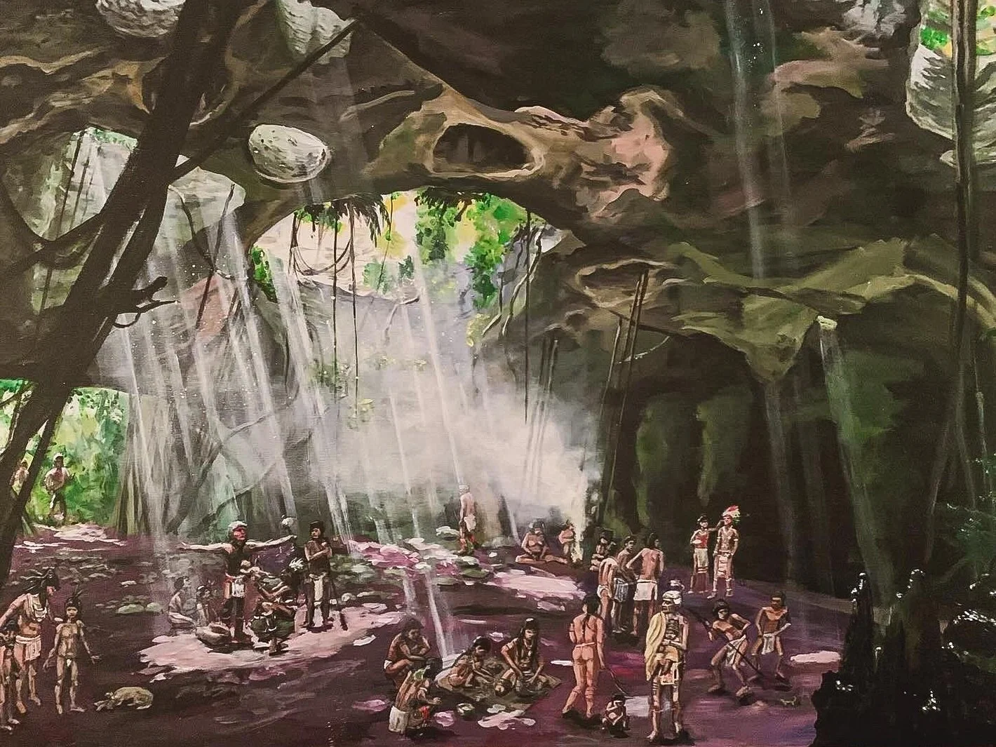Painting of a group of indigenous people inside a large cave with waterfalls, rocks, and lush greenery, some people are standing, kneeling, or sitting, engaged in various activities.