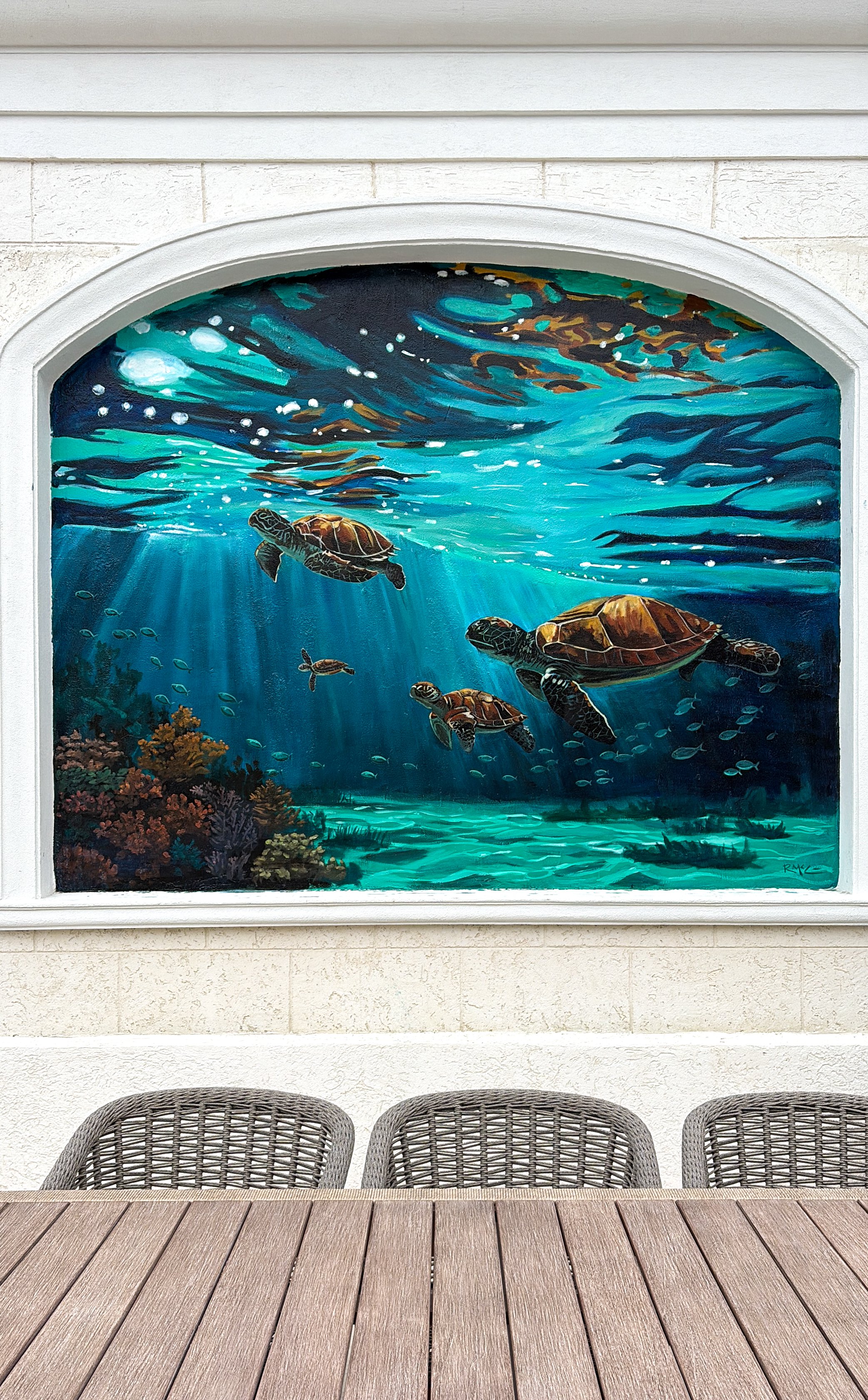Turks and Caicos mural of an underwater scene with turtles swimming near coral, with sunlight rays shining through blue water.