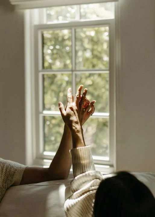 Couple reaching for each other by a sunlit window, couples and sex therapy in Coral Gables, Miami