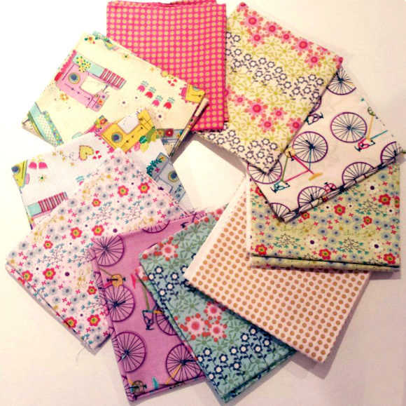 Stacked and spread out fabric squares with various colorful floral and bicycle patterns.