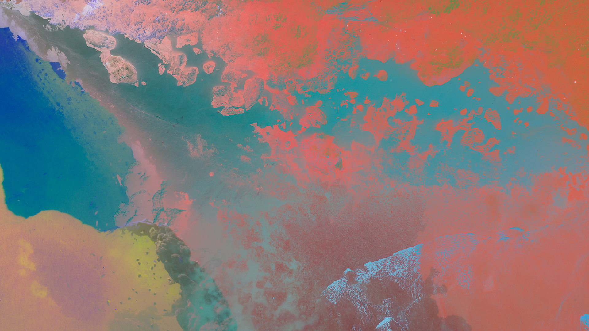 Abstract aerial view of land and water with vibrant colors, showing rocky shoreline and ocean waves.