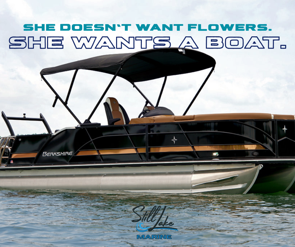 A black and tan Berkshire pontoon boat on the water with a canopy, and a text overlay that says, "She doesn't want flowers. She wants a boat."
