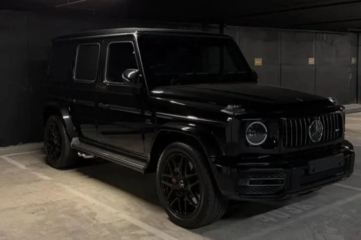Black Mercedes-Benz G-Class SUV parked in a dimly lit underground garage.