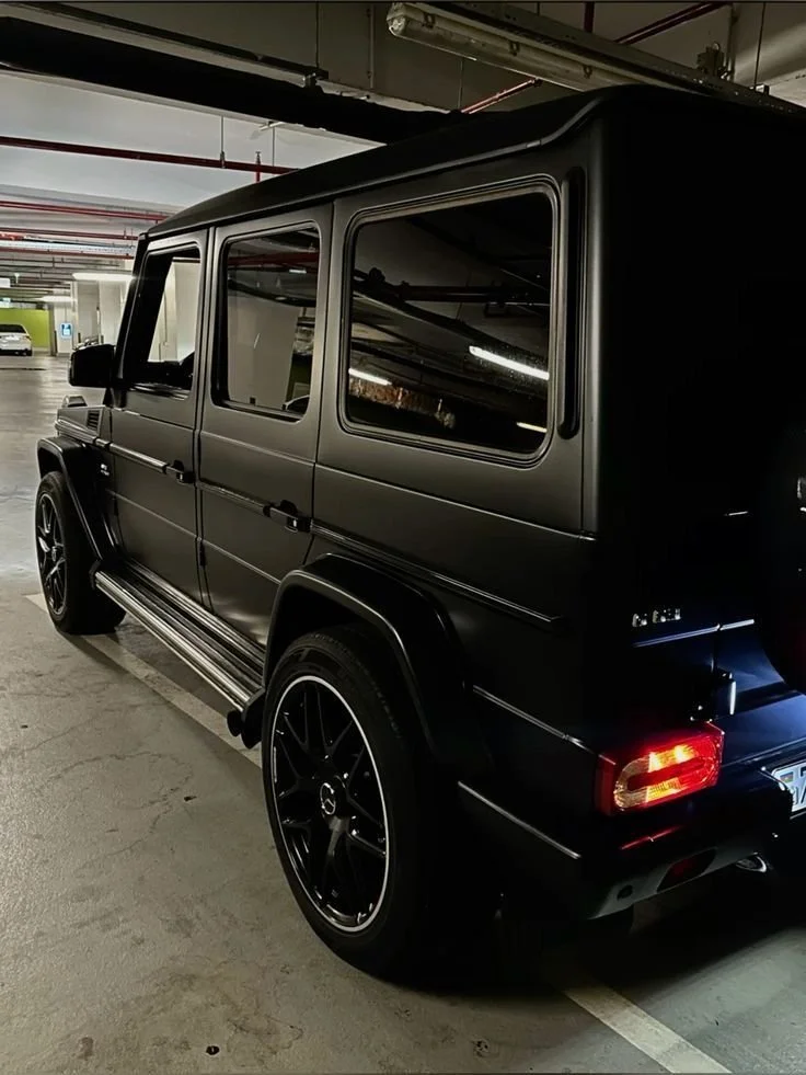 Black Mercedes-Benz G-Wagon parked in an underground parking garage.