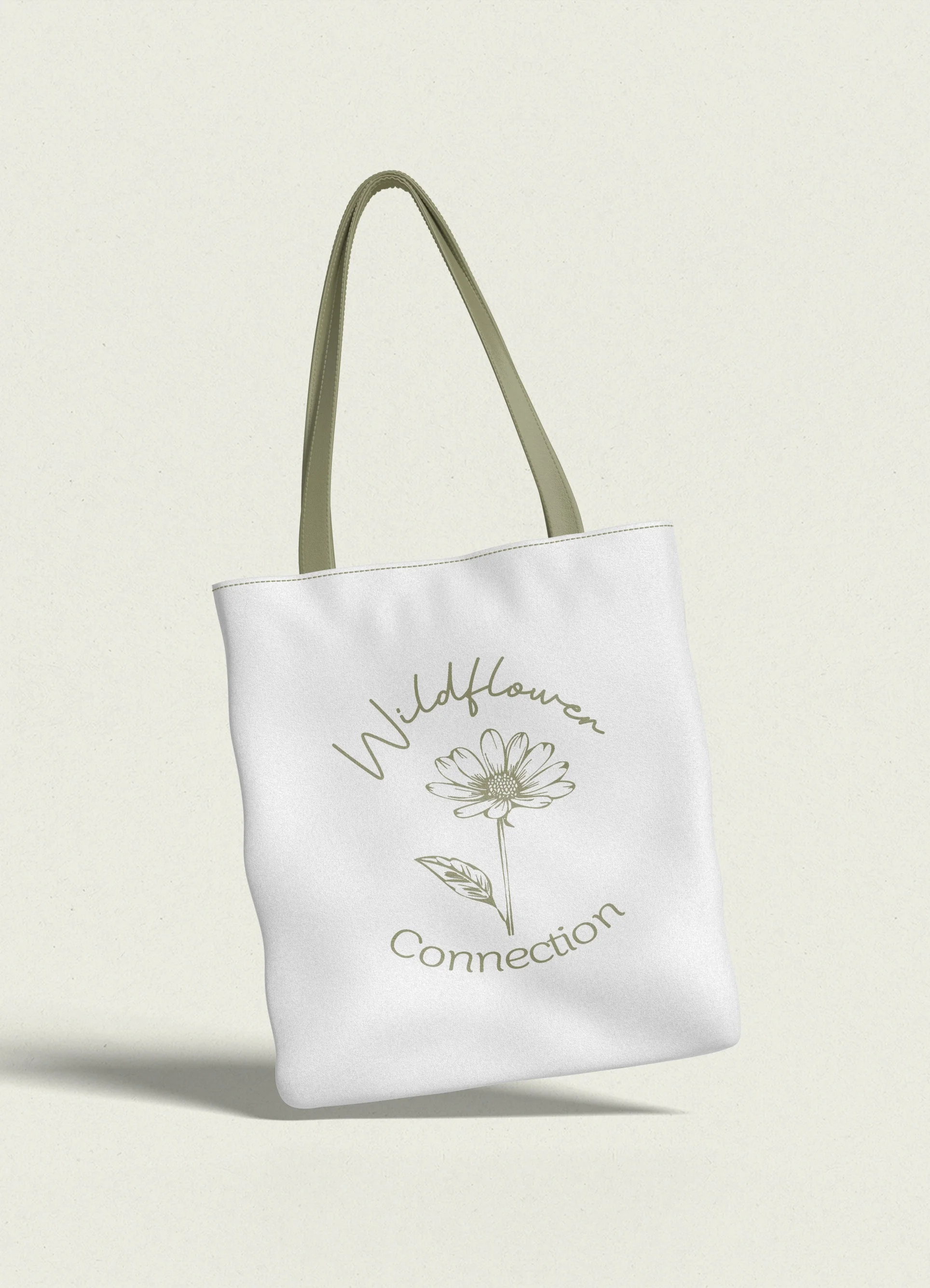 White tote bag with the words 'Wildflower Connection' and a line drawing of a flower and leaf in muted green.
