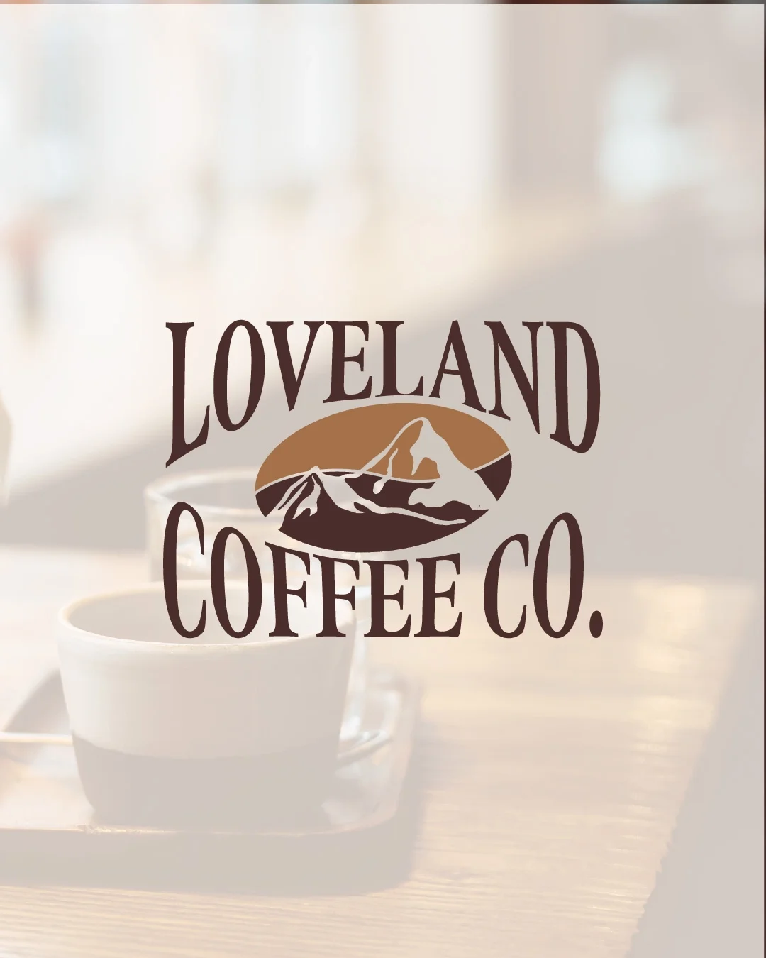 Logo for Loveland Coffee Co. with mountains and coffee cup in the background