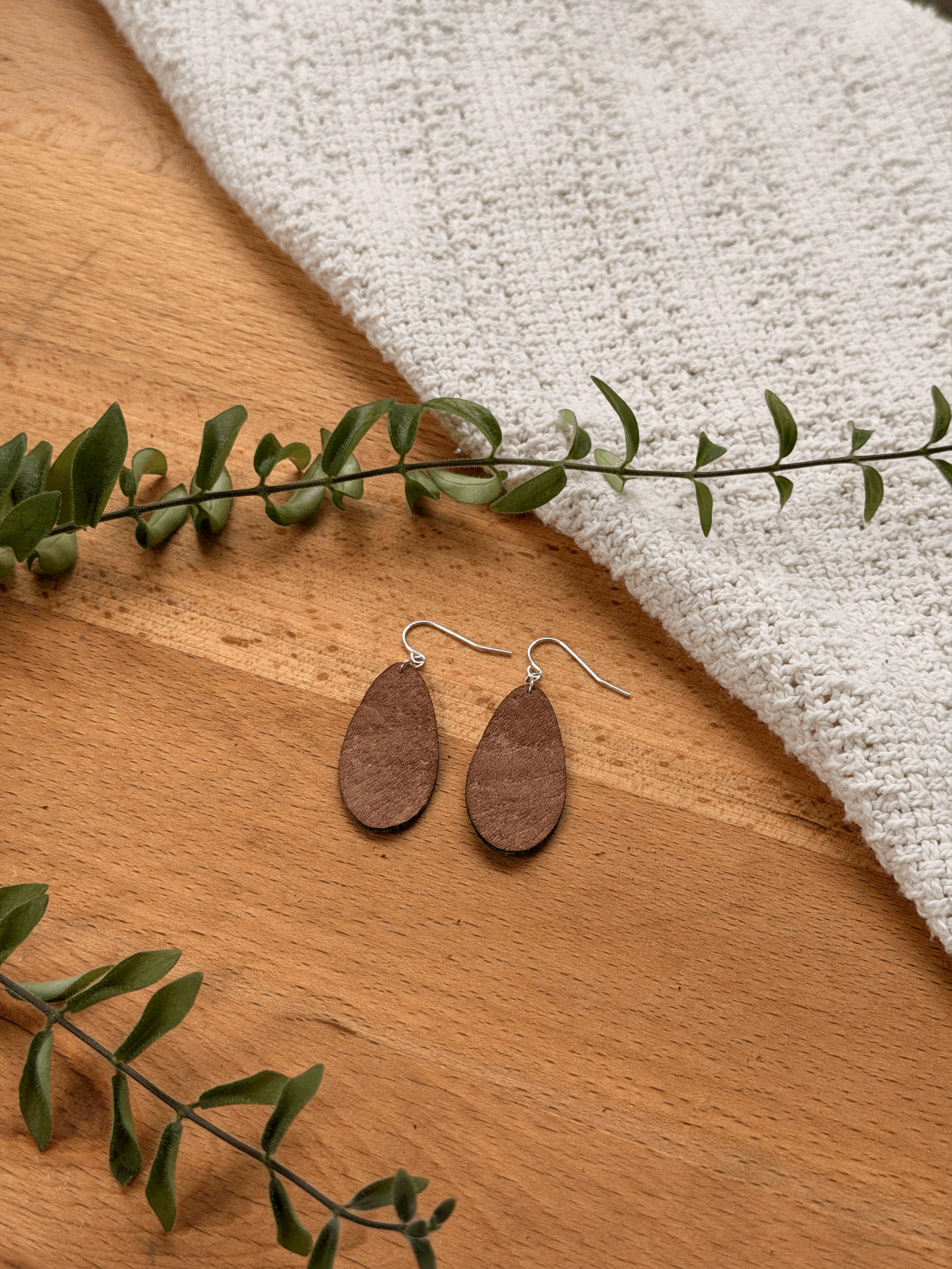 Rounded teardrop earrings shown in small size and Oak finish