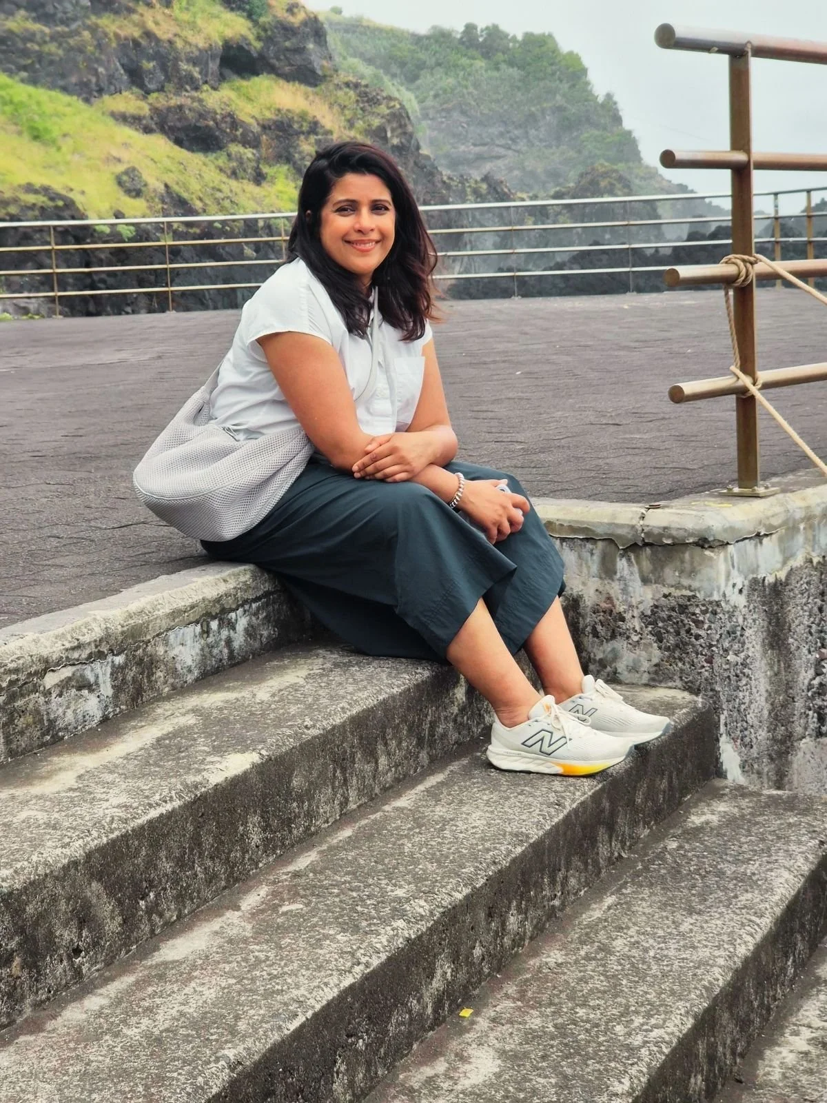 Founder of Studio Ambrene sitting on stone steps outdoors