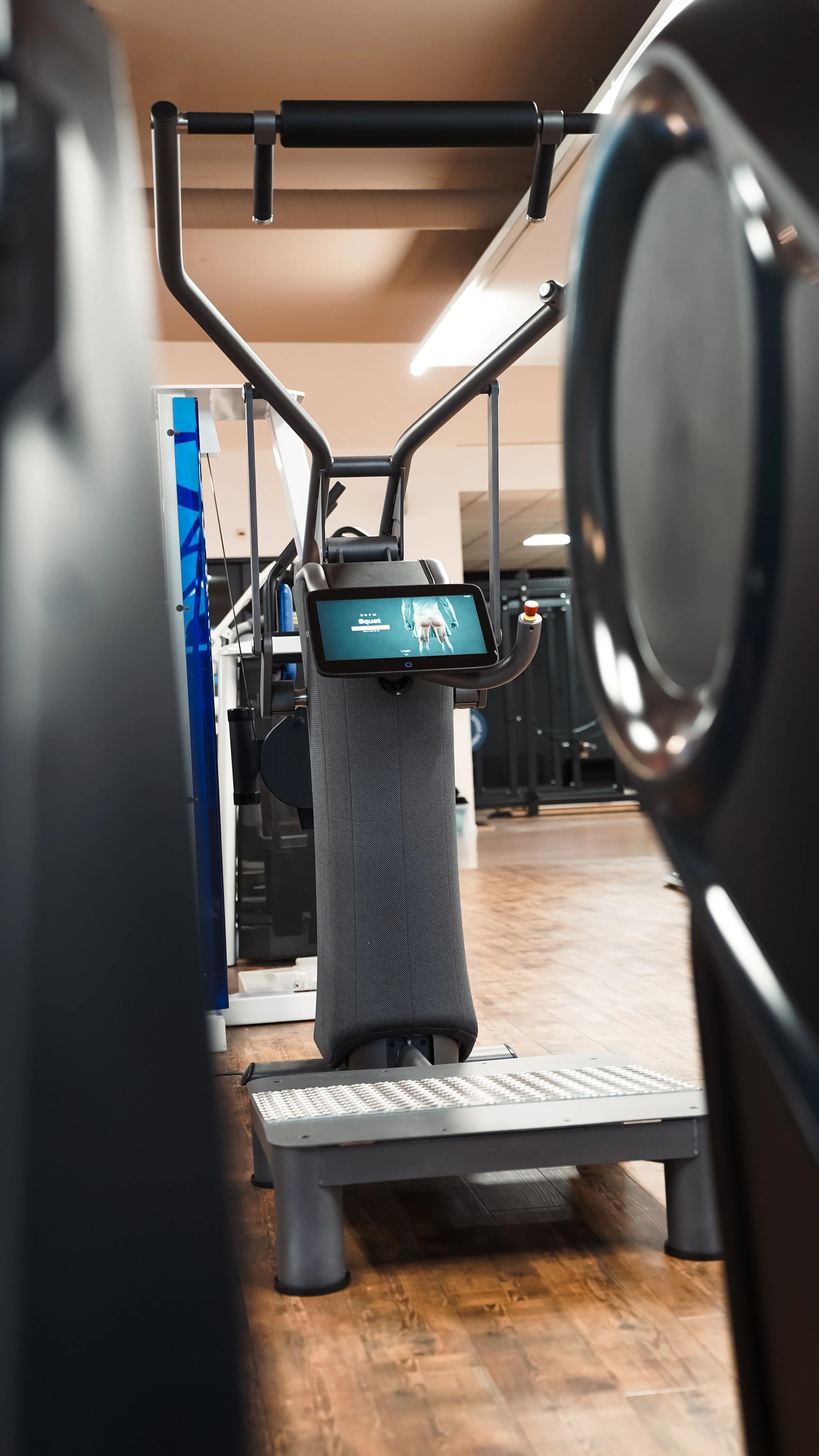 Blick auf ein Laufband im Fitnessstudio, das von mehreren Geräten umgeben ist.