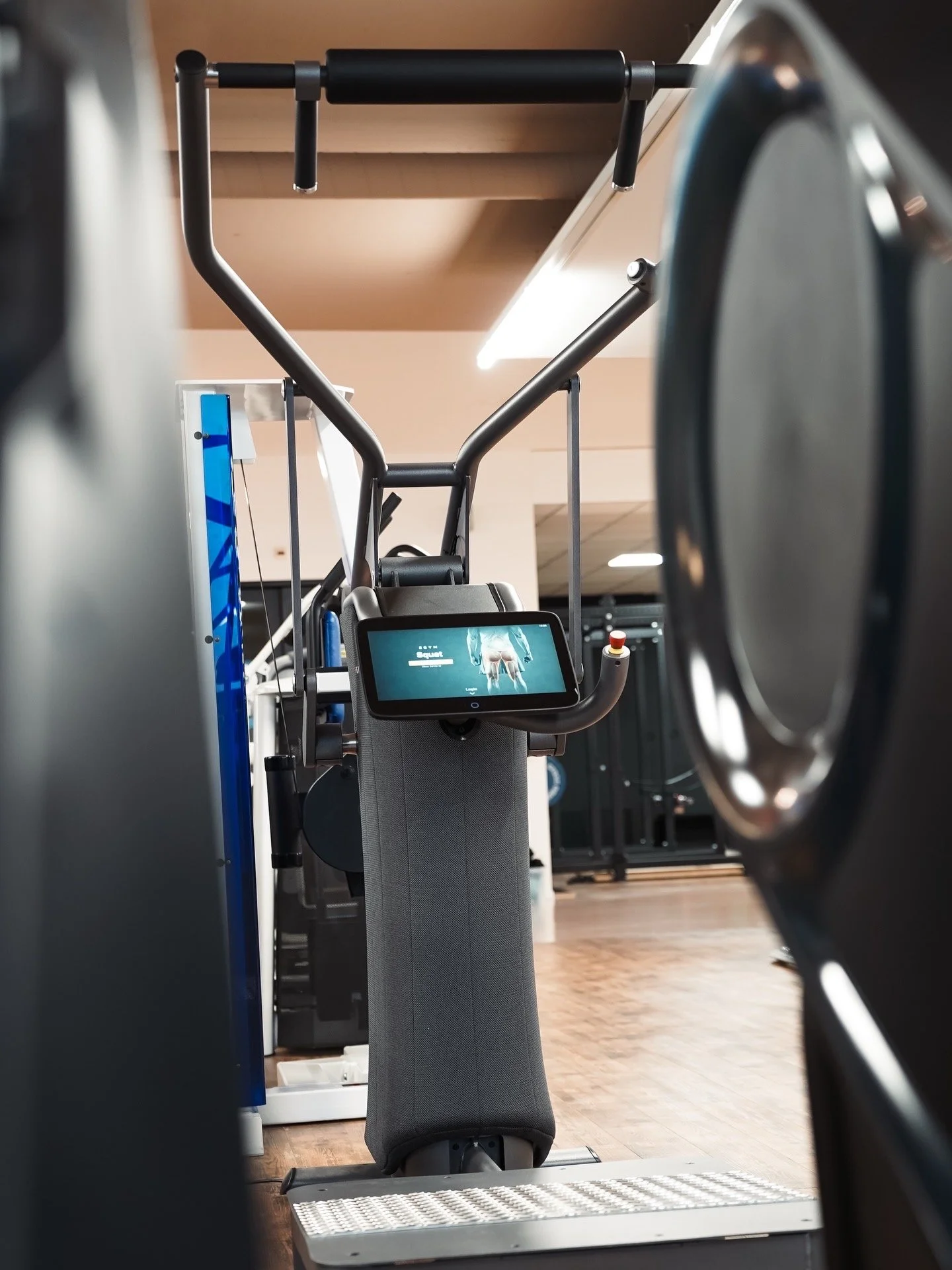 Fitnessgerät im Fitnessstudio mit digitaler Anzeige, umgeben von anderen Trainingsgeräten.