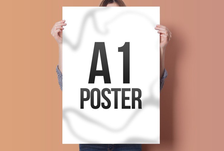 Person holding an A1 poster with black text on a white background, standing in front of a two-tone wall.