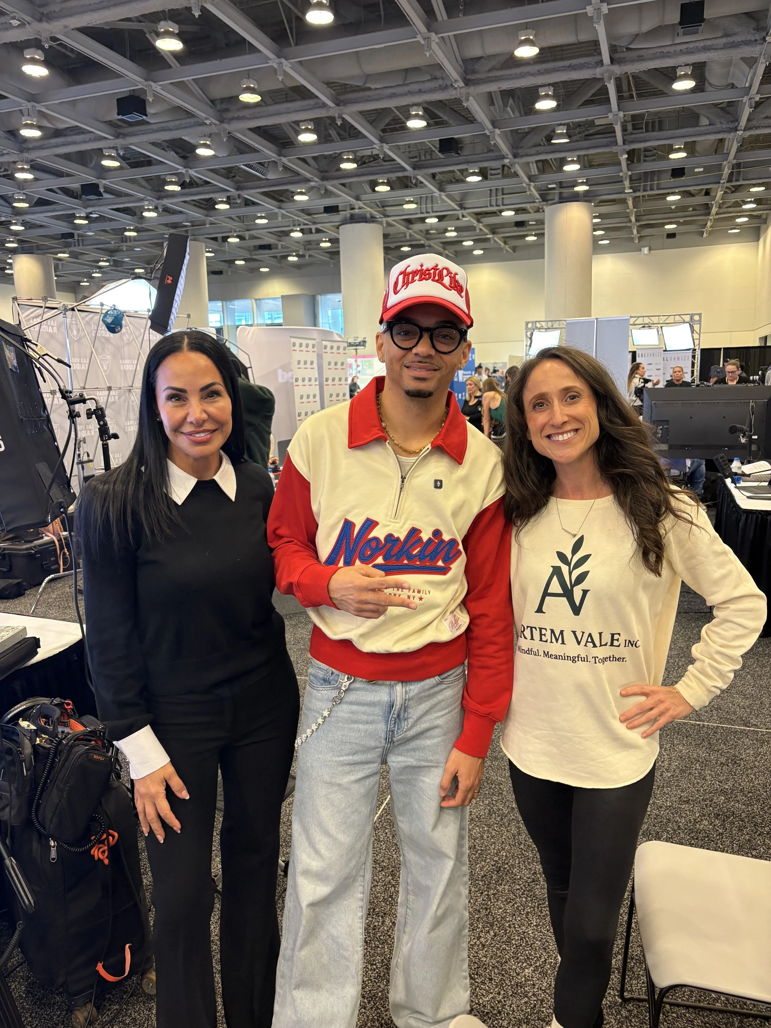 NFL football player Miles Minnick with Artem Vale foundation and Arian May at Superbowl LX for mental health