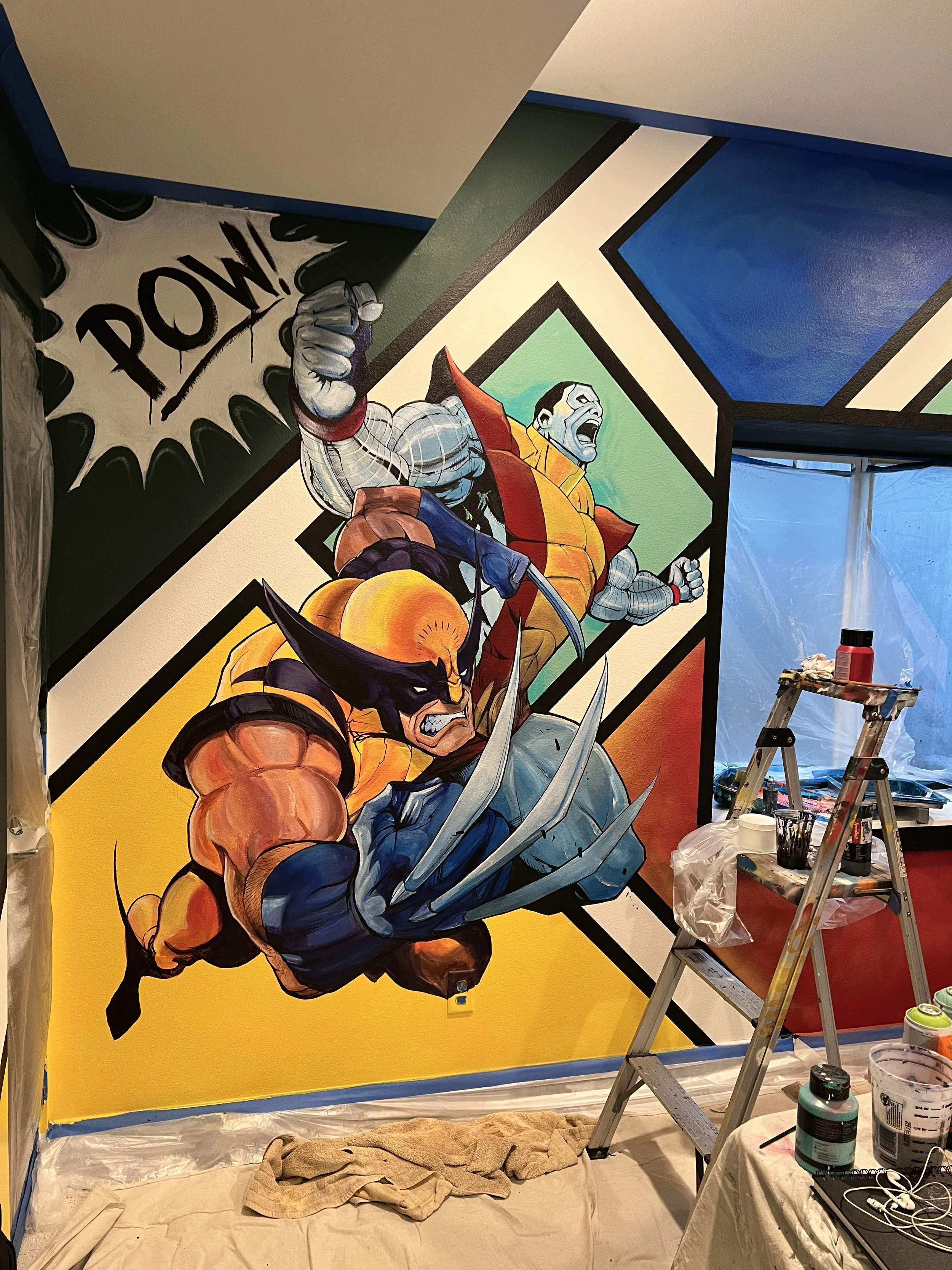 Colorful comic book style mural featuring Wolverine and Venom from Marvel Comics. Wolverine is in the foreground with claws extended, while Venom is in the background shouting with his mouth open.