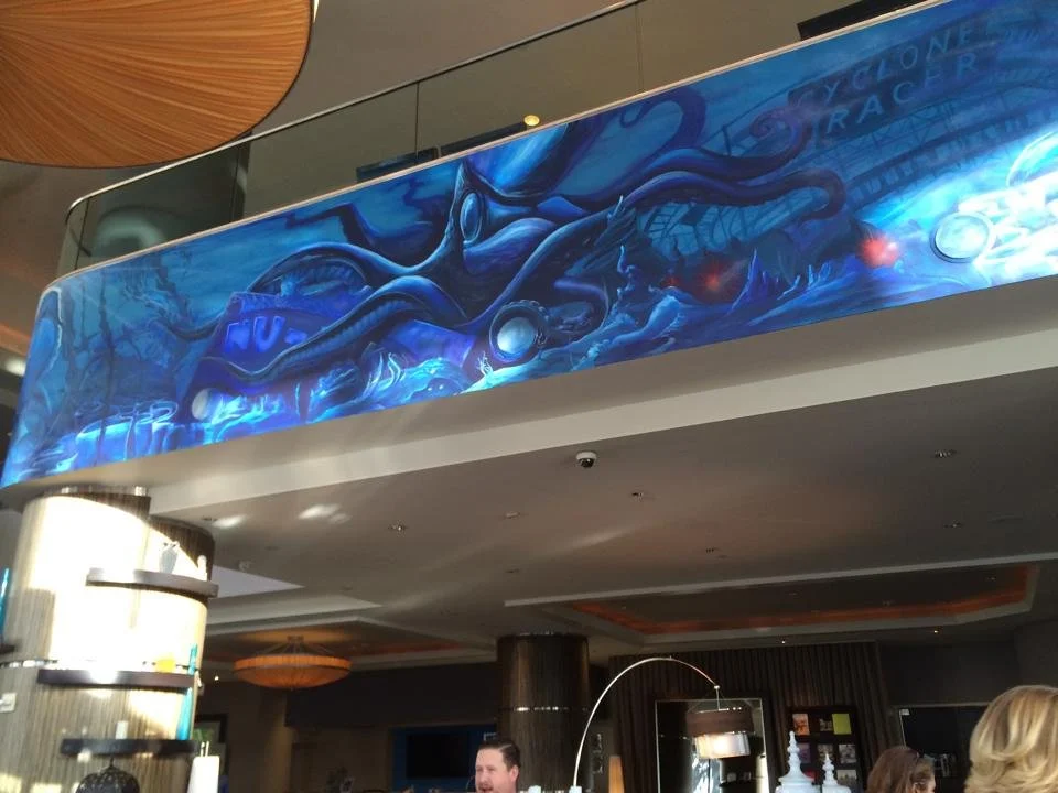 Blue and black mural of a whale and tentacles on a hotel or convention center wall.