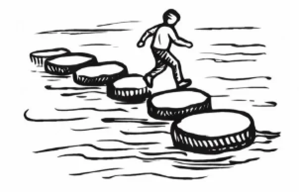 A person crossing a series of stepping stones over water.