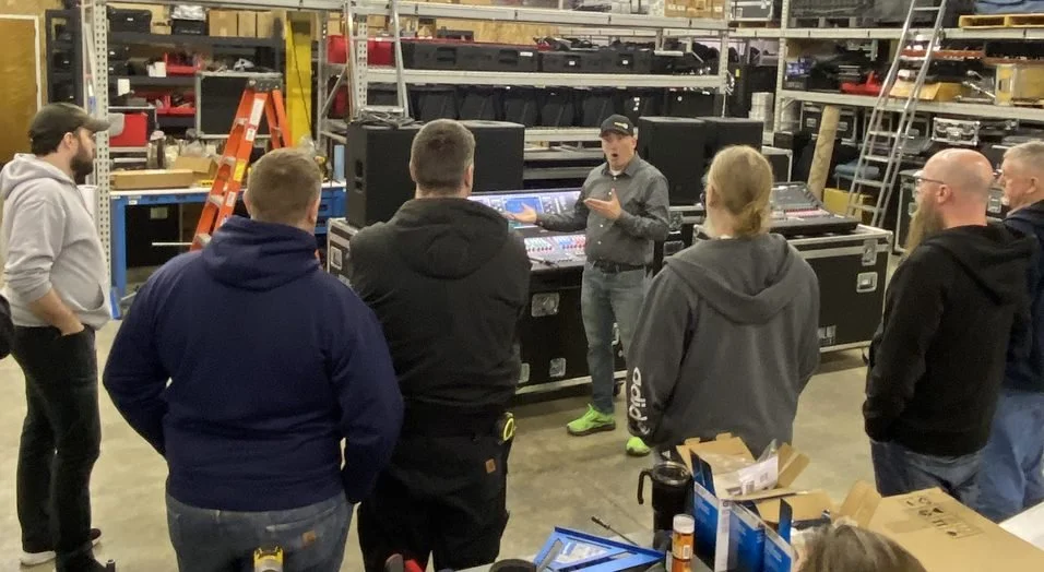 Technicians receive a demonstration from a brand representative