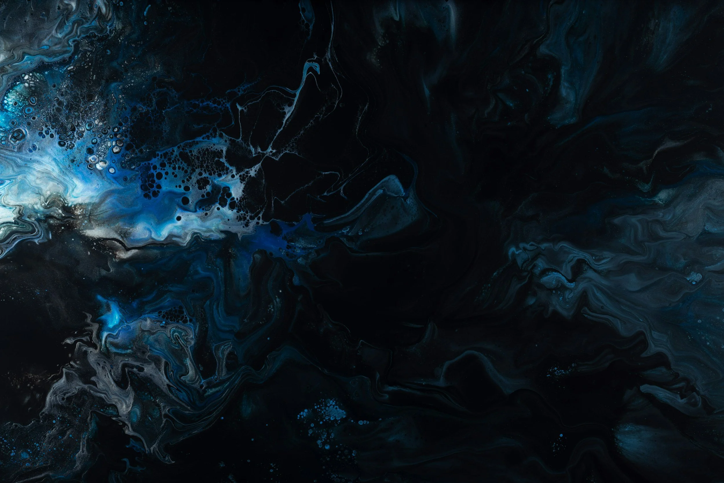 Un quadro astratto con sfumature di blu, nero e bianco, simile a un cielo o a un mare in tempesta e un scritta strategia & sviluppo