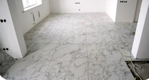 Empty room with marble tile flooring and white walls.