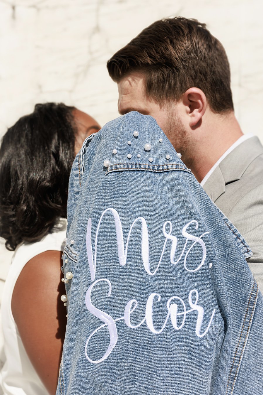 Engagement photo at DIA in Detroit of a couple kissing behind a denim jacket
