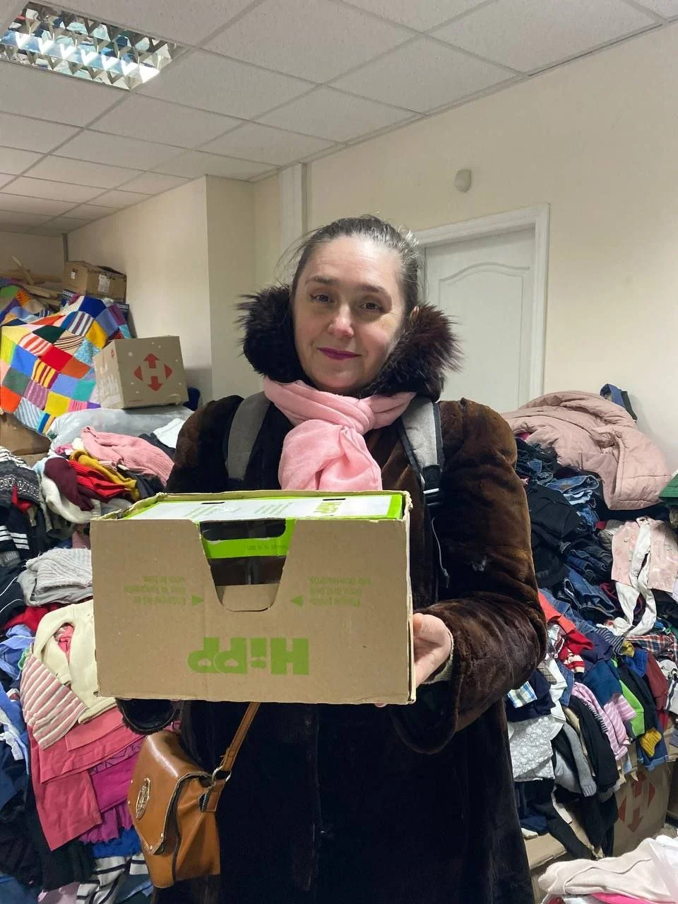 A smiling women receiving aid at warehouse.