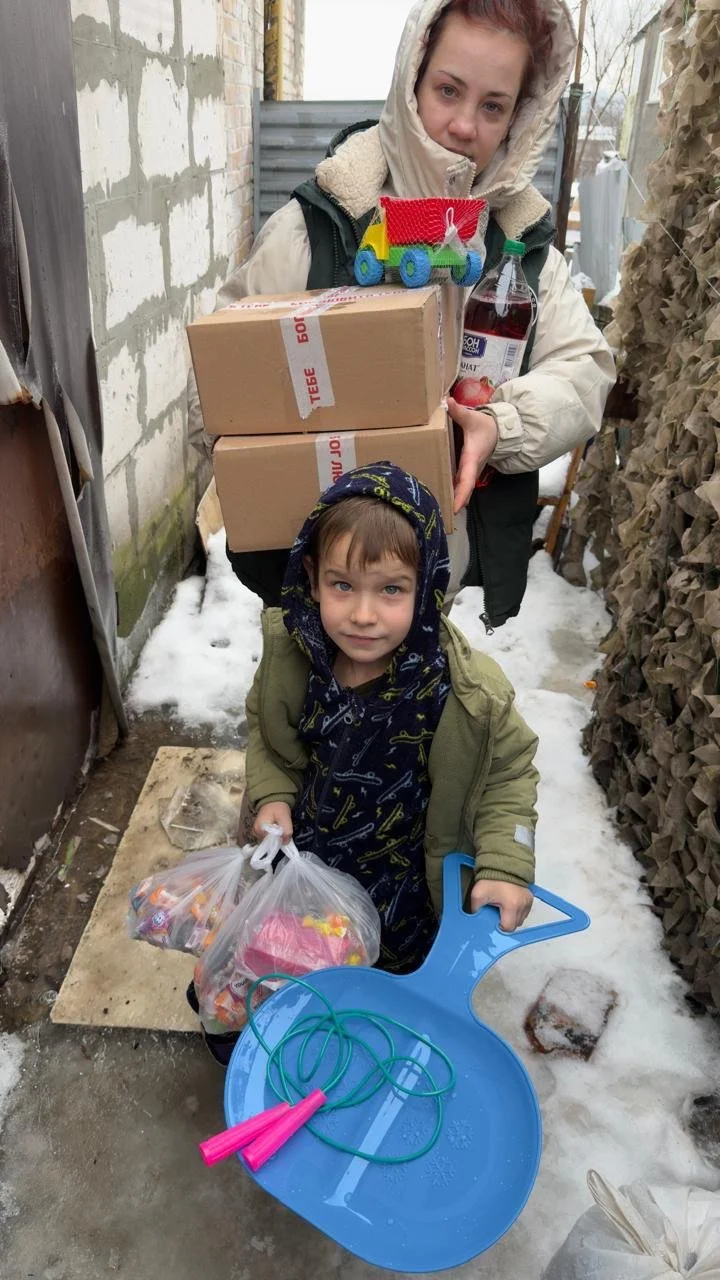 A woman and a young child receiving aid in a village near the front lines