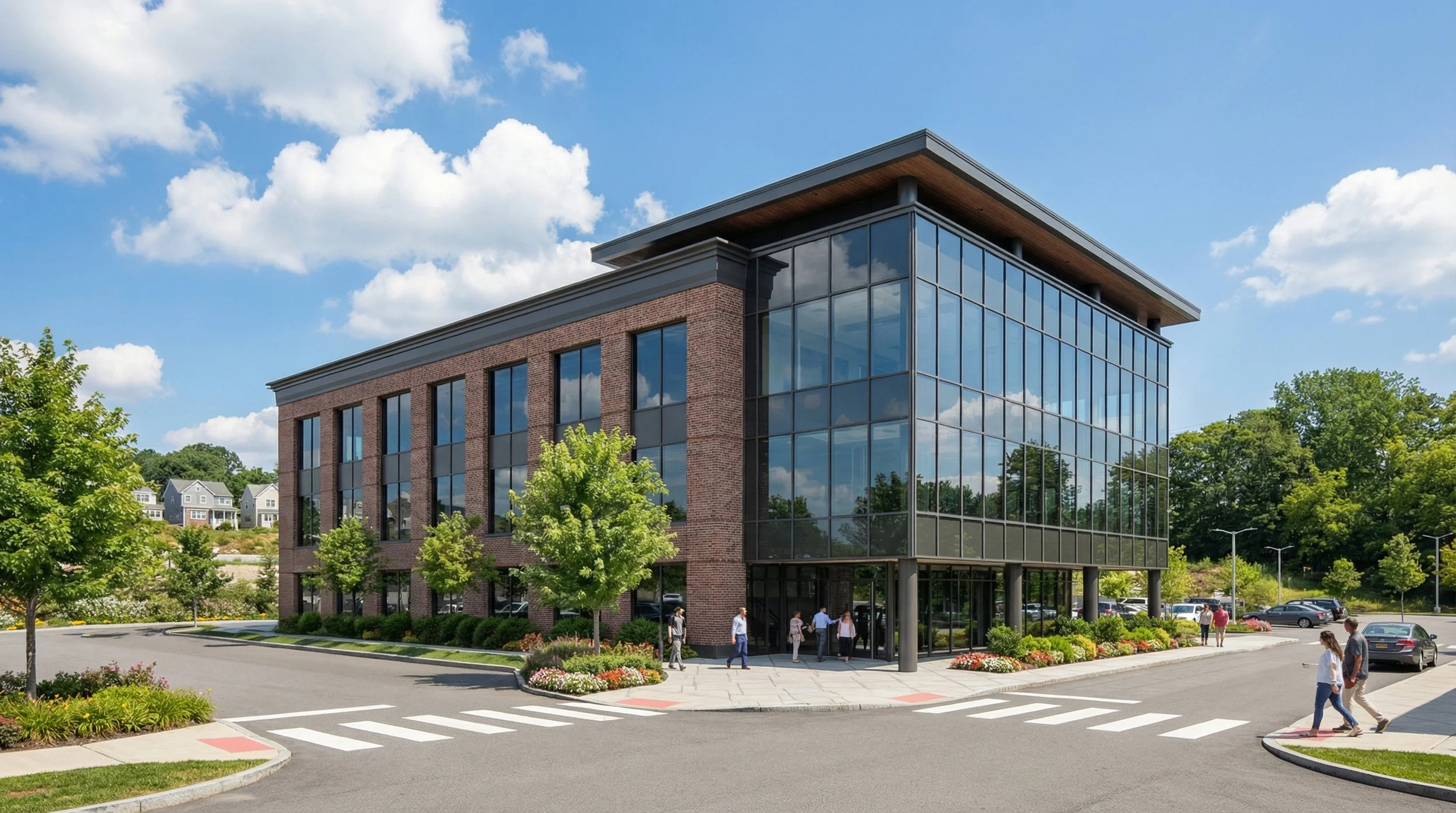 Modern office building with reflective glass windows, brick accents, surrounded by trees and a parking lot, with a few people walking near the entrance on a sunny day. New York, New Construction, Medical Office, Architecture, Design