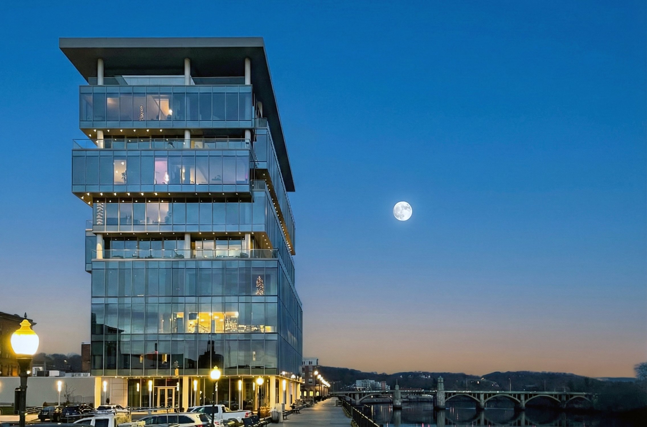Modern glass building near water at dusk with the moon in the sky. Massachusetts, new construction, residential, architecture