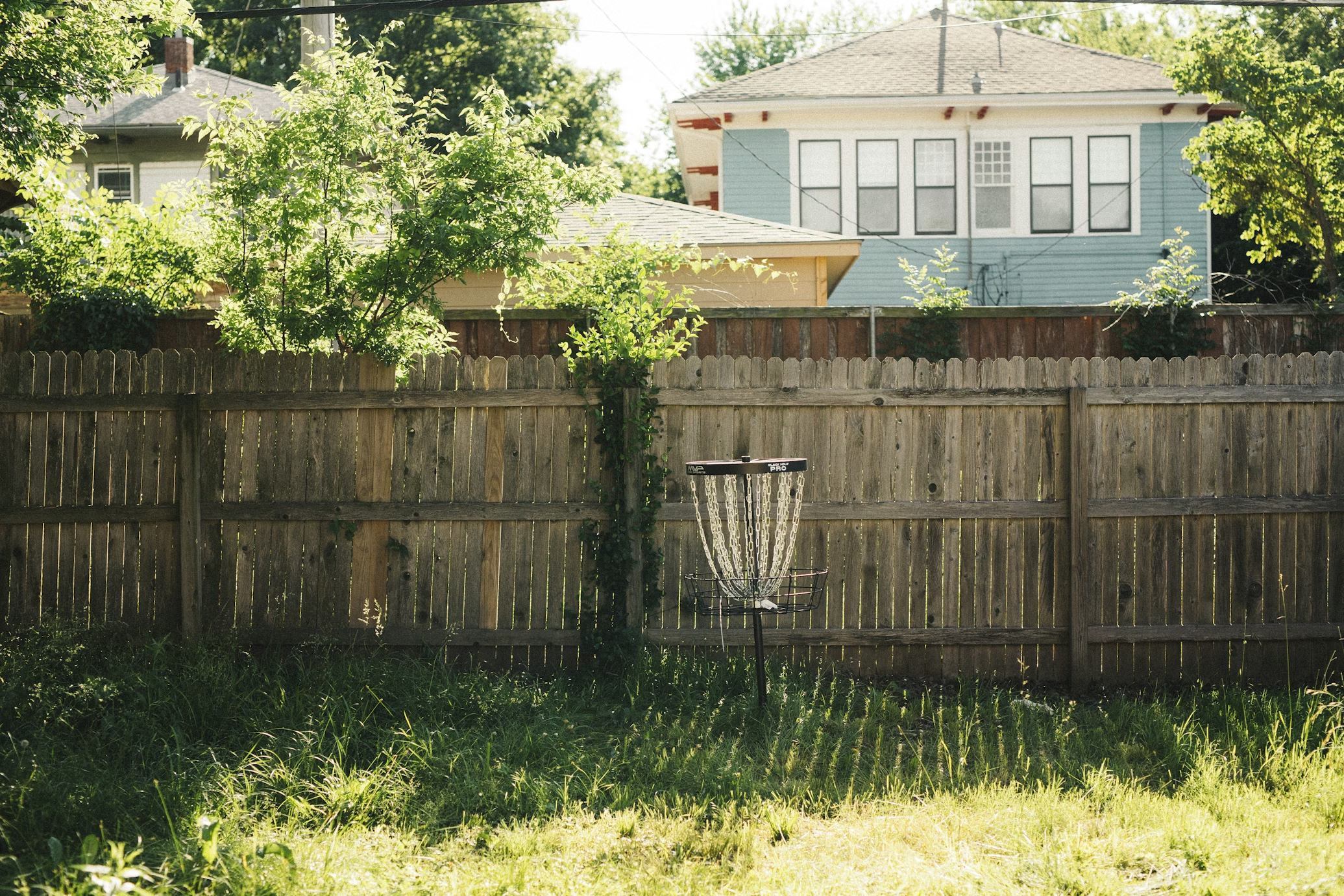 Fenced backyard in Alaska with open lawn and trees, ideal for mosquito control treatment in the Mat-Su Valley