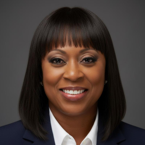 Professional headshot of a smiling Black woman with shoulder-length straight hair and bangs, wearing a dark blazer and a white shirt against a gray background.