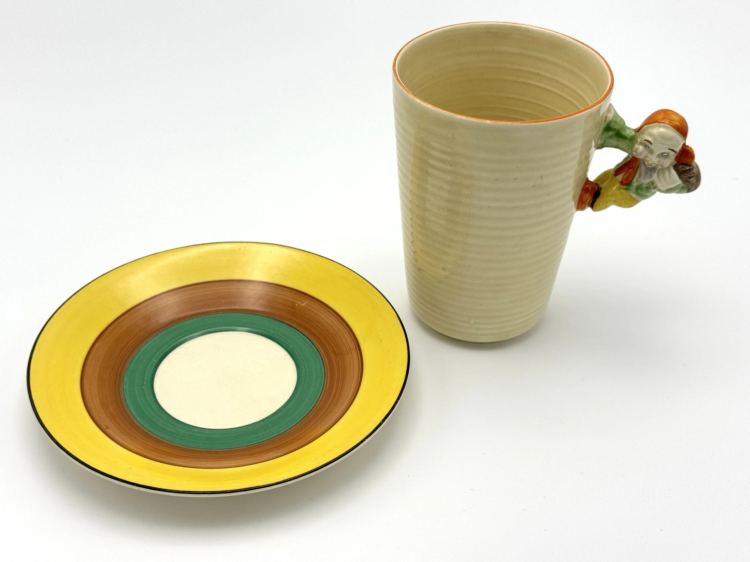 Clarice Cliff, "Pixie" Handel mug and Saucer, c.1930's