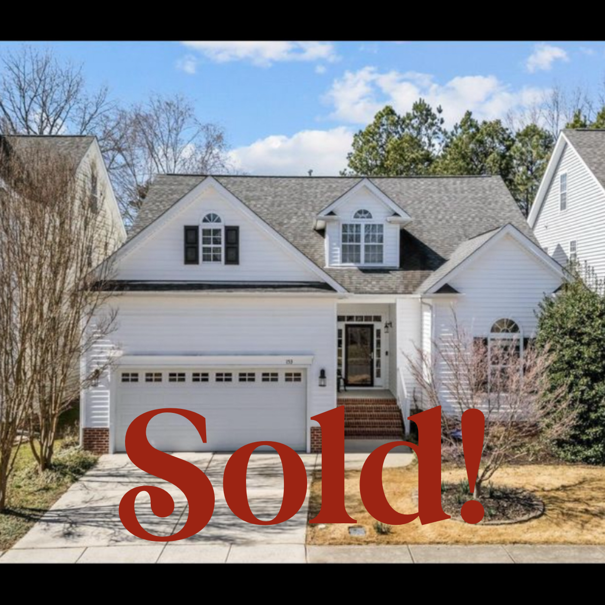 Front view of a white two-story house with a garage, stairs, and trees in a suburban neighborhood with a "Sold!" label overlaid.