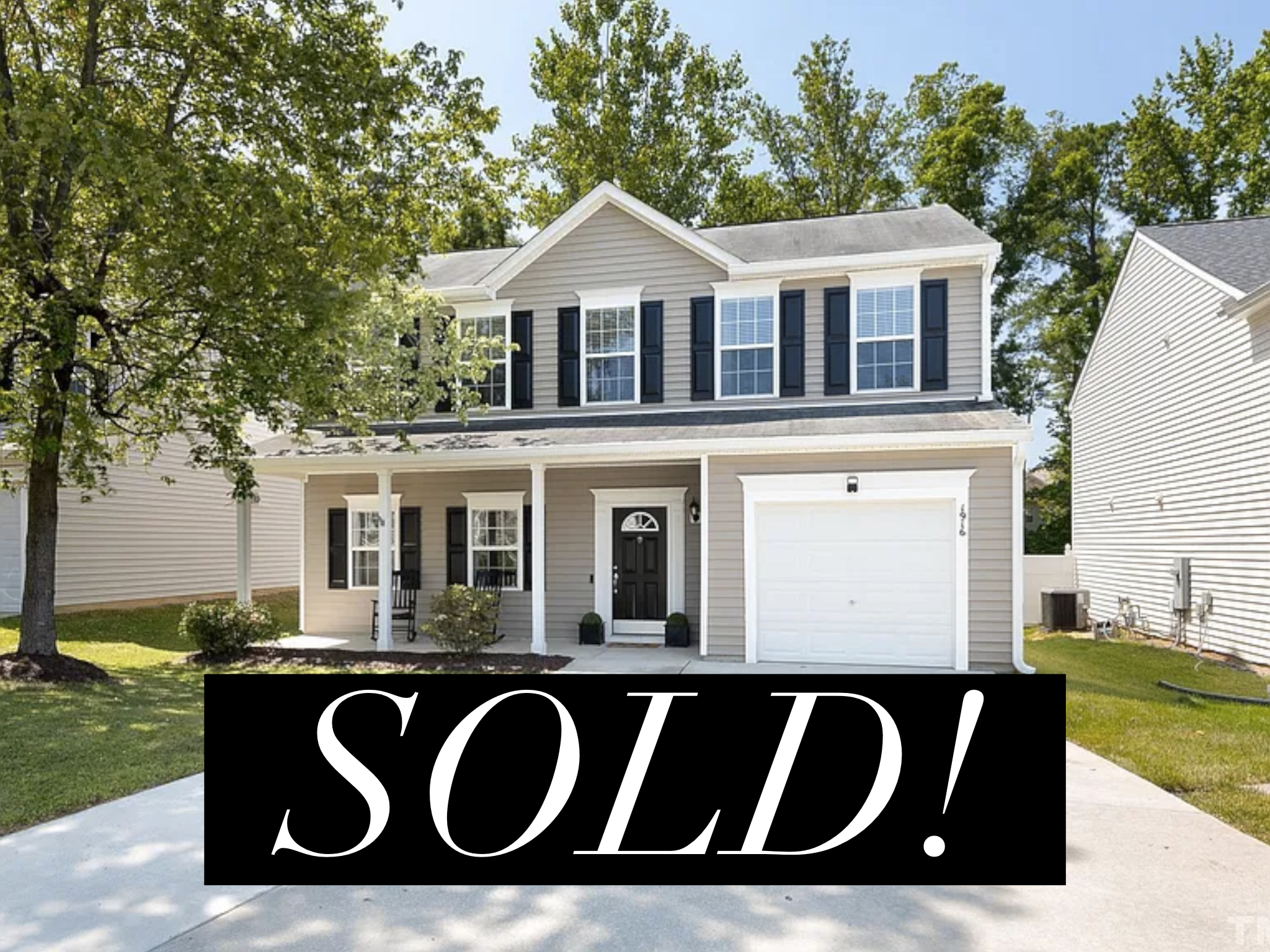 Two-story house with beige siding, black shutters, front porch with two chairs, and a white garage door, marked as sold.