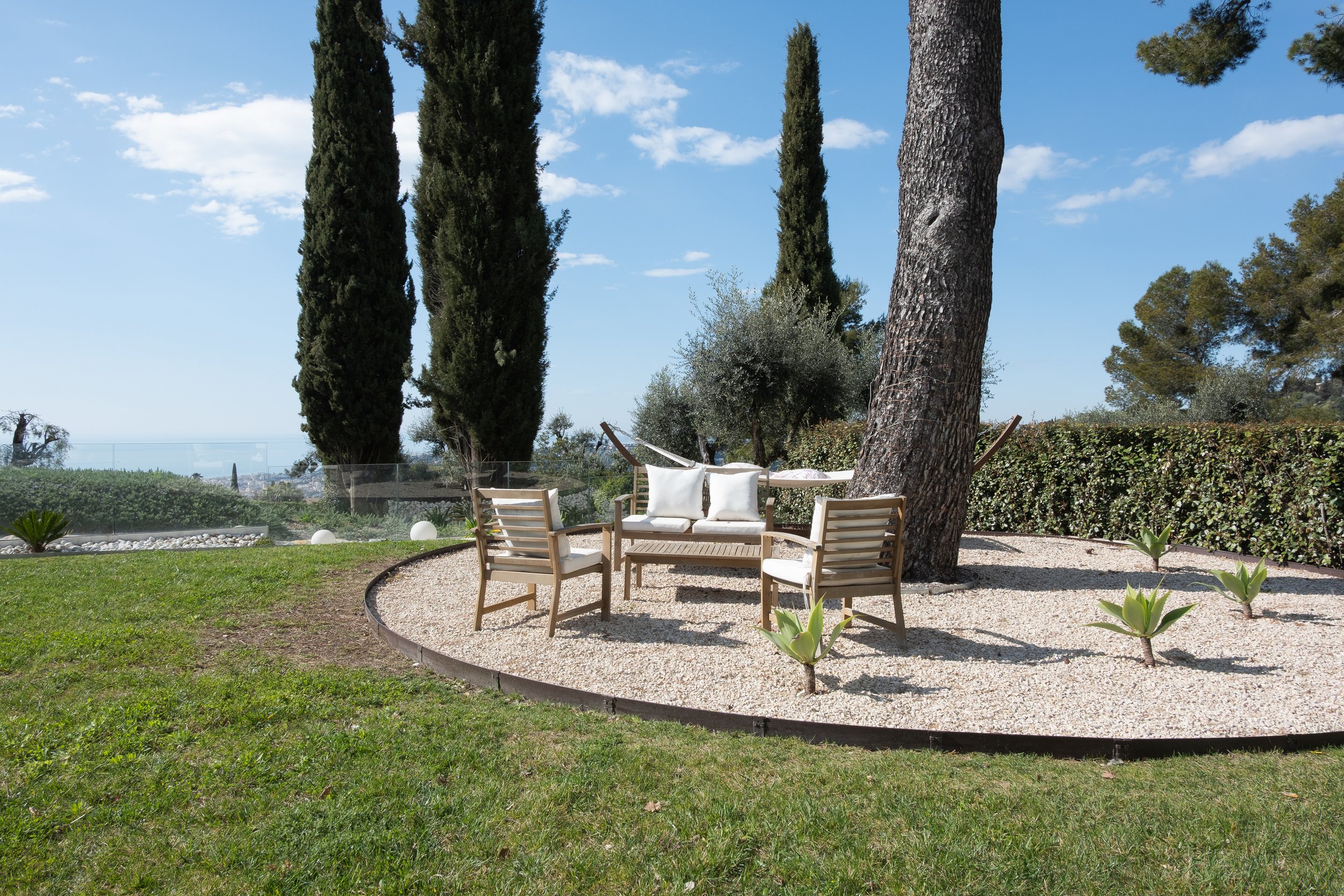 Photographie immobilière d'extérieur mettant en avant le salon de jardin, la vue et la superficie.