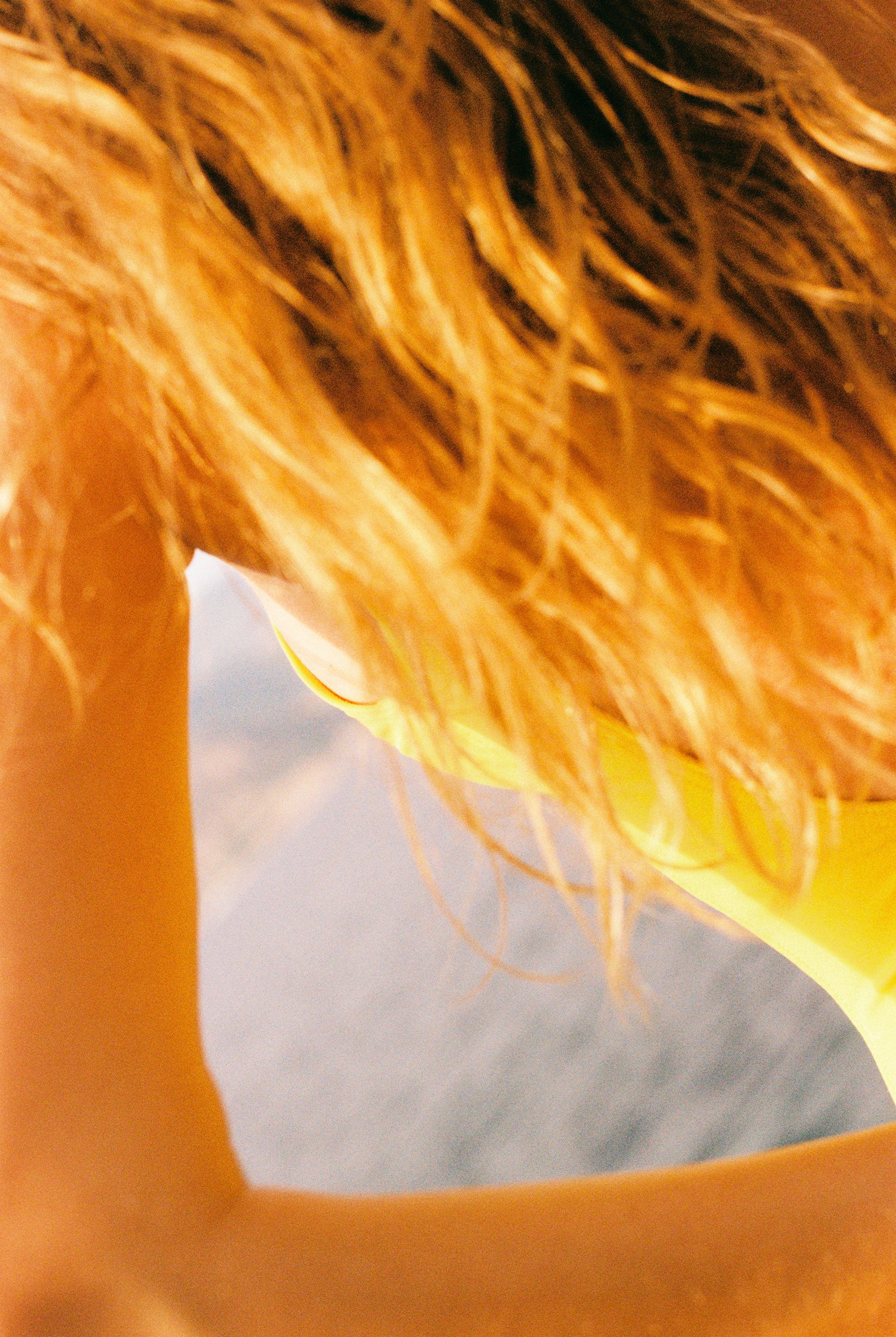Photo of a female body showing her back, her arm, her hair, her yellow bathing suit and the ocean in the background. Warm ambiance. The light points at her breast, directing the look towards it.
Photo taken in Saint-Jean-Cap-Ferrat (South of France, 