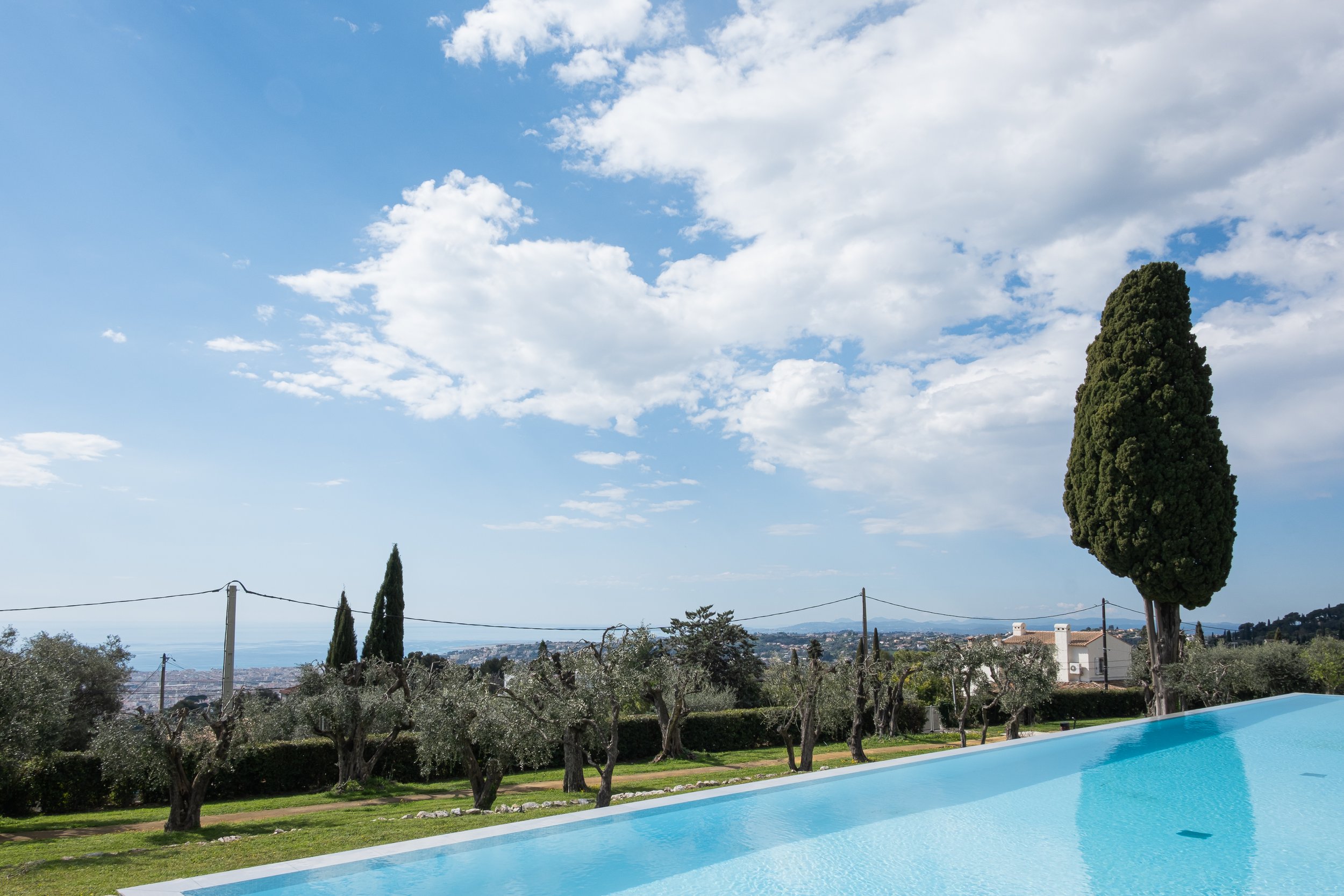 Photographie immobilière d'extérieur mettant en avant la piscine et la vue mer.