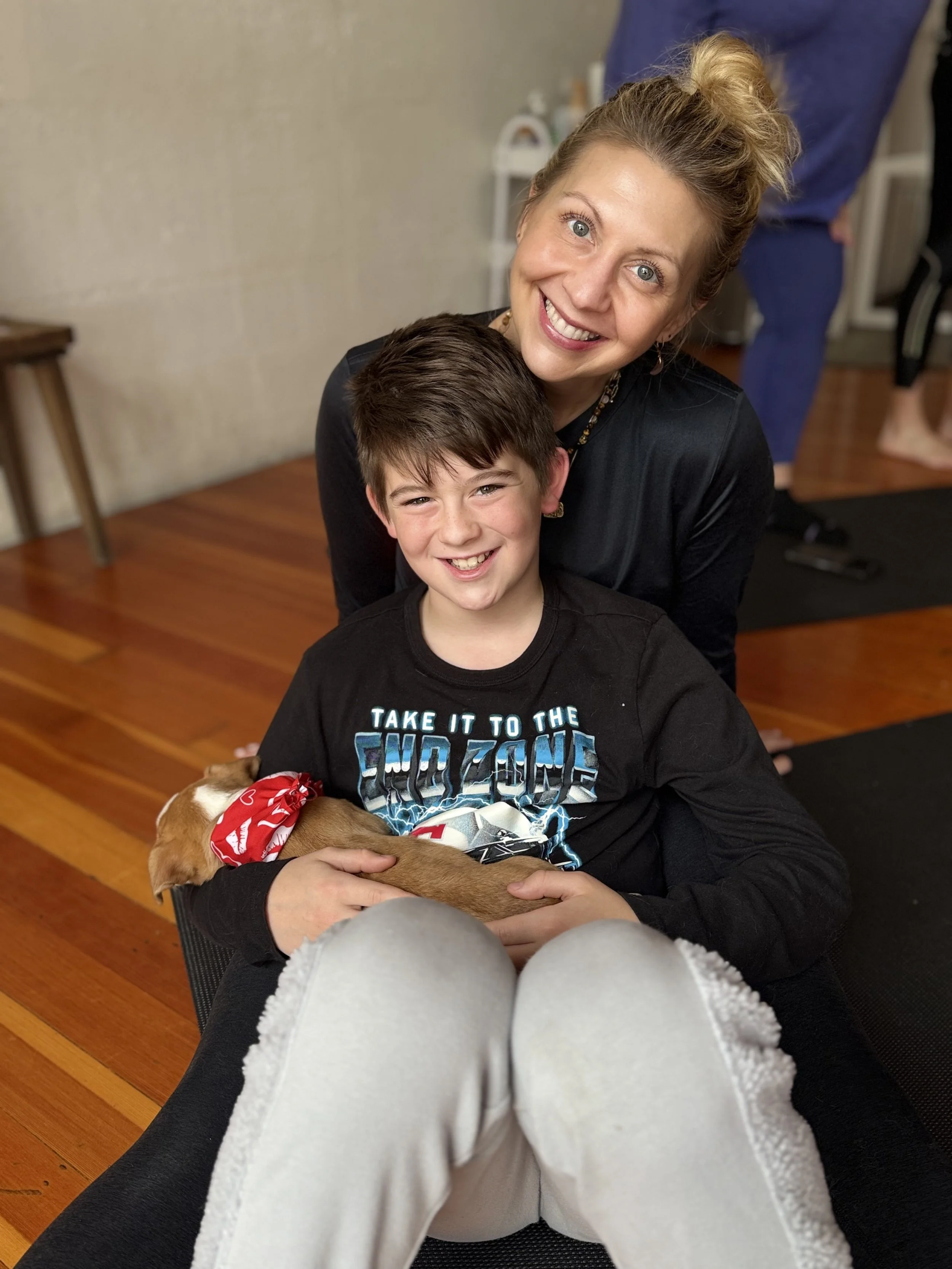 Child and mom posing with puppies at the Puppy Yoga 2026 VIP event in Portland, OR