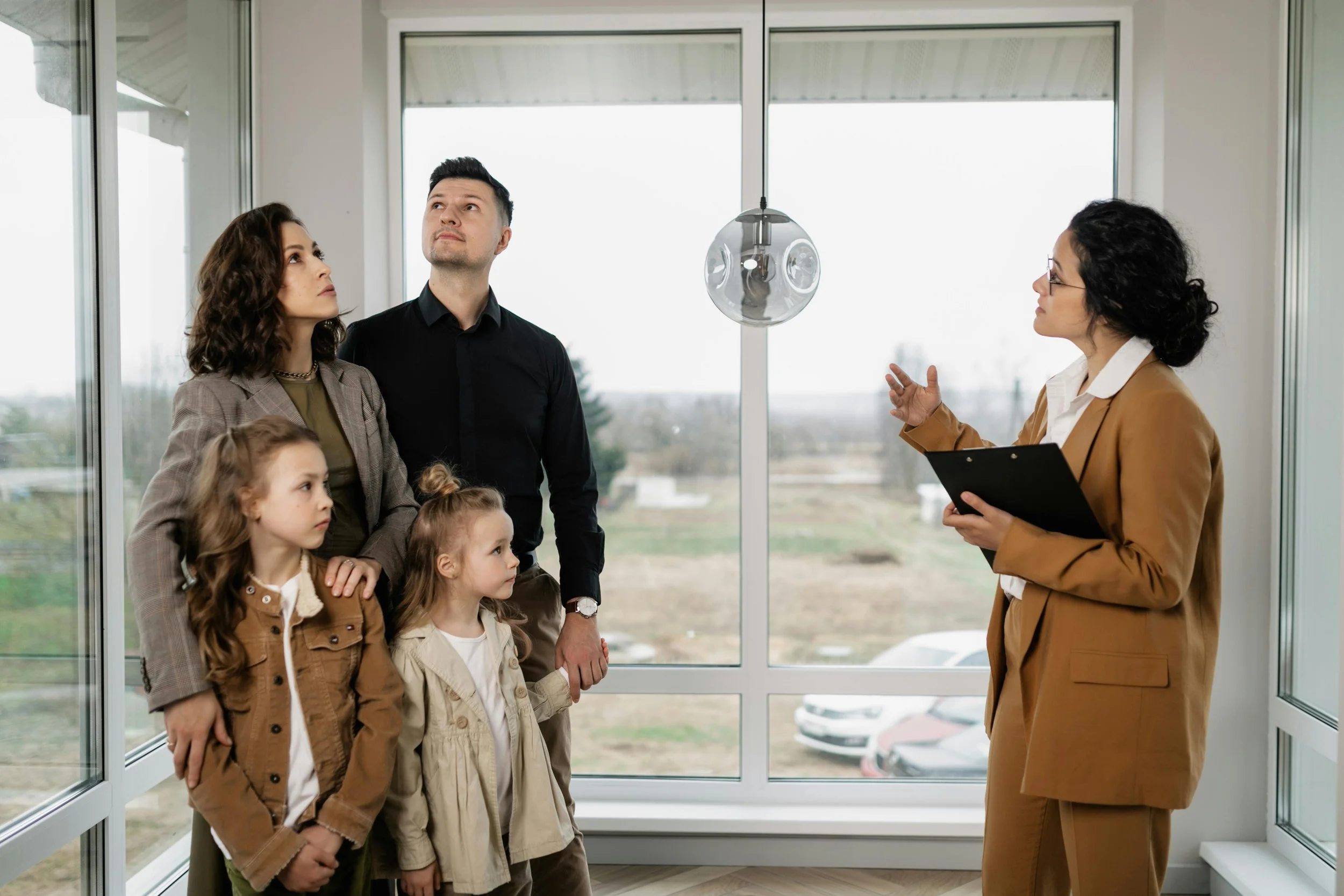 Rhonda Riley guiding a growing family through a move-in ready home, helping them evaluate their must-haves versus nice-to-haves.