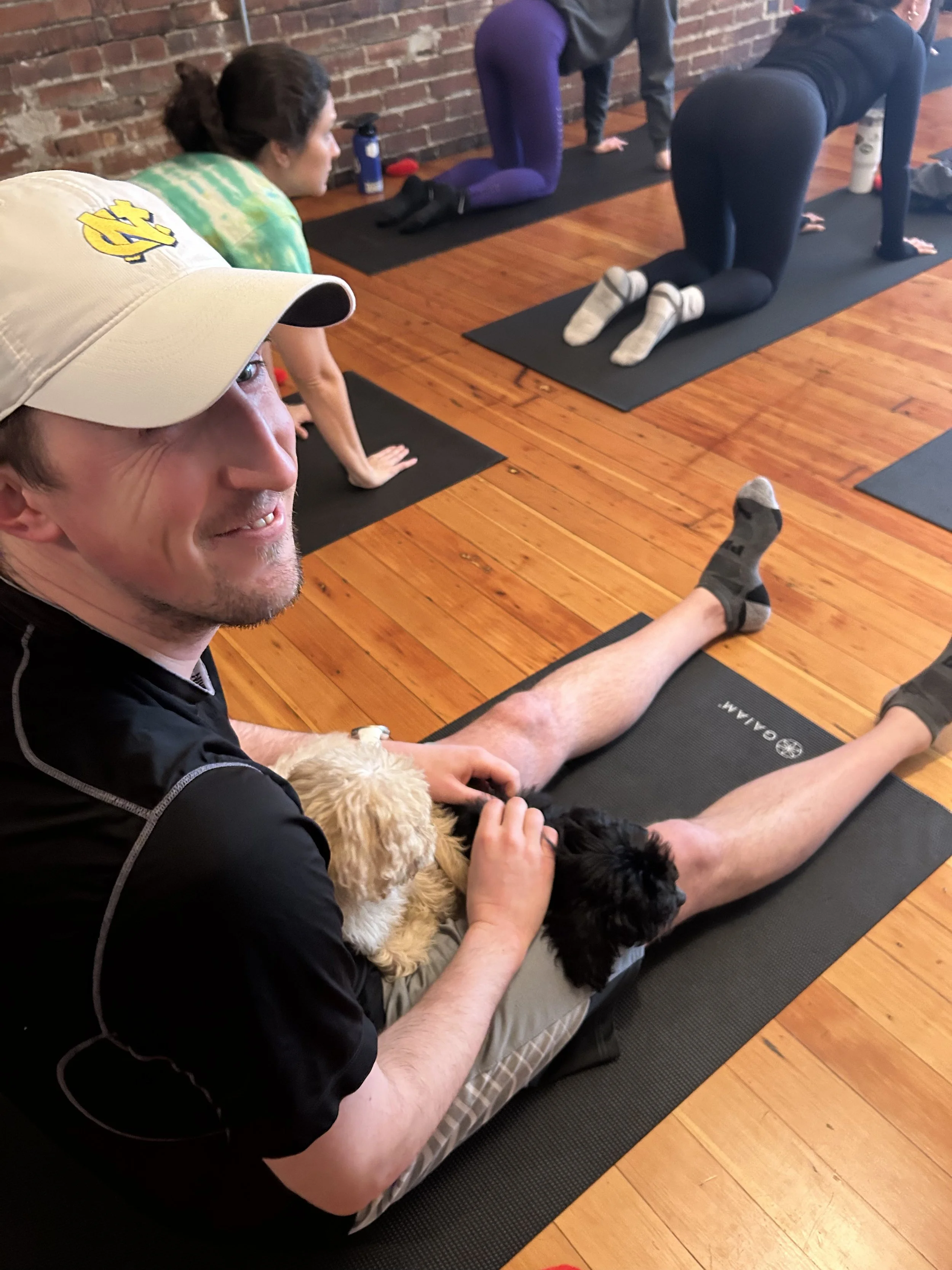 Smiling clients enjoying Puppy Yoga 2025 with puppies at a community event in Portland, OR