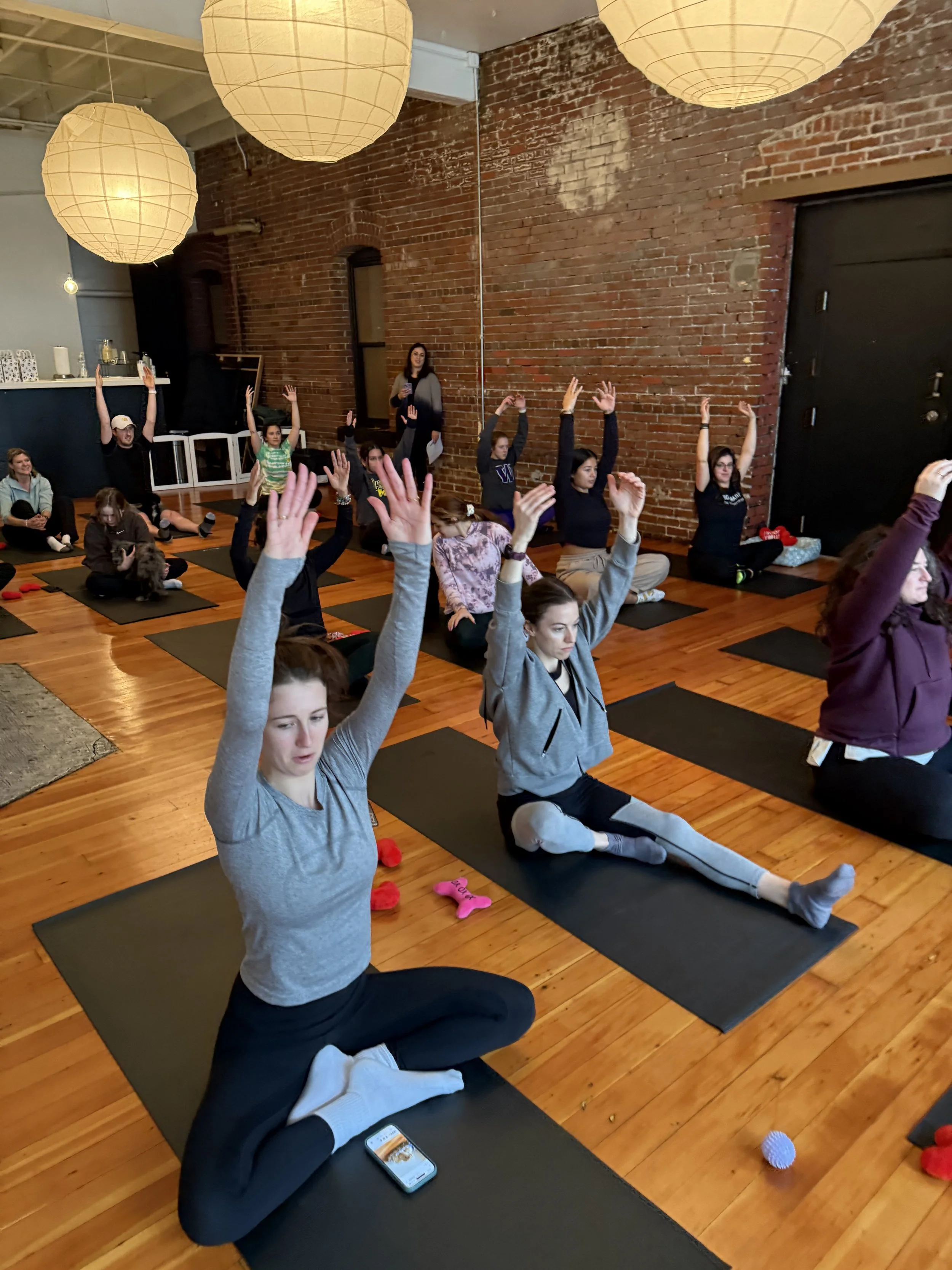 Friends enjoying yoga and puppies at the Puppy Yoga 2025 VIP client event in Portland, OR