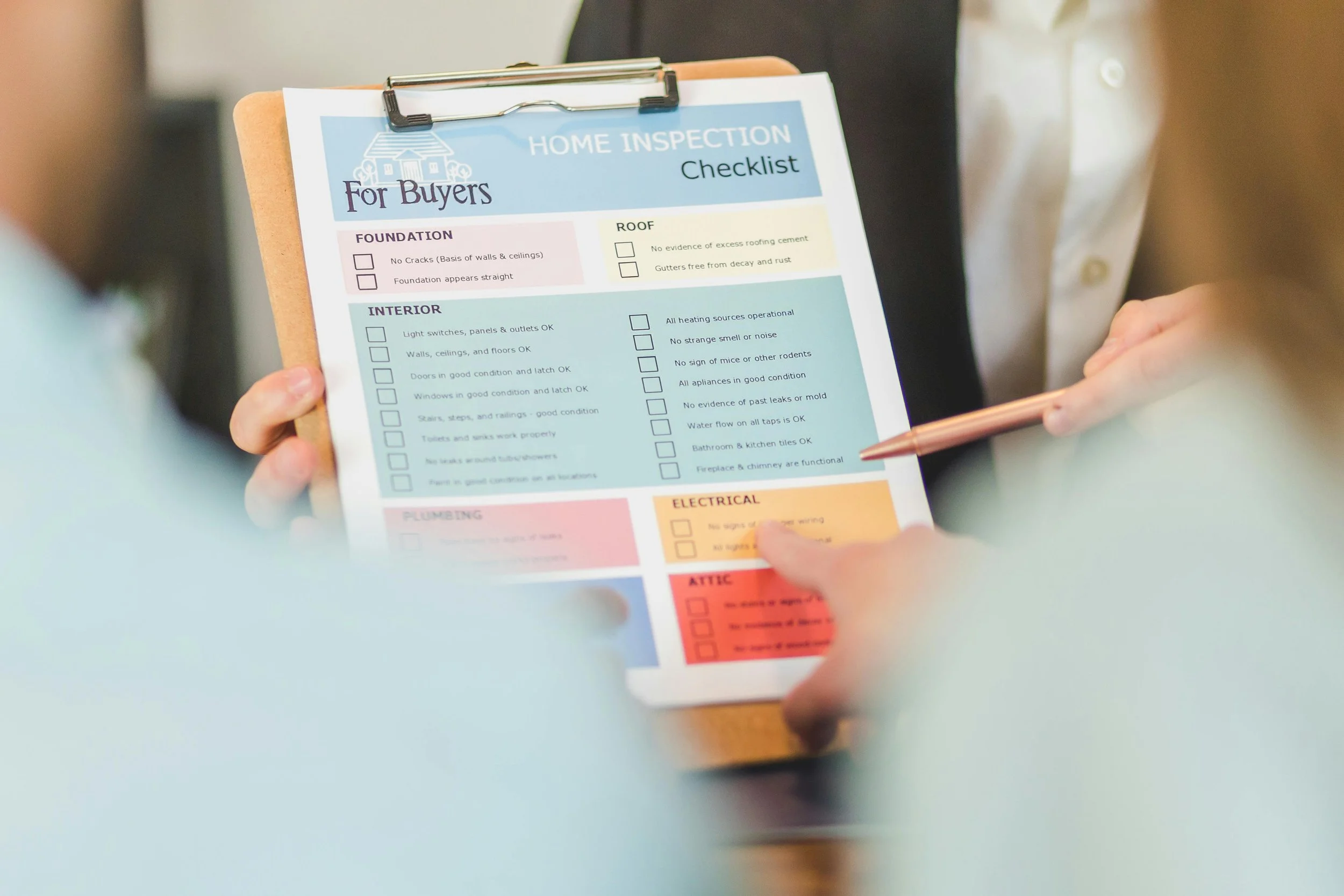 A close-up of a 'Home Inspection Checklist for Buyers' on a clipboard being reviewed during a real estate transaction in Forest Grove, Oregon.